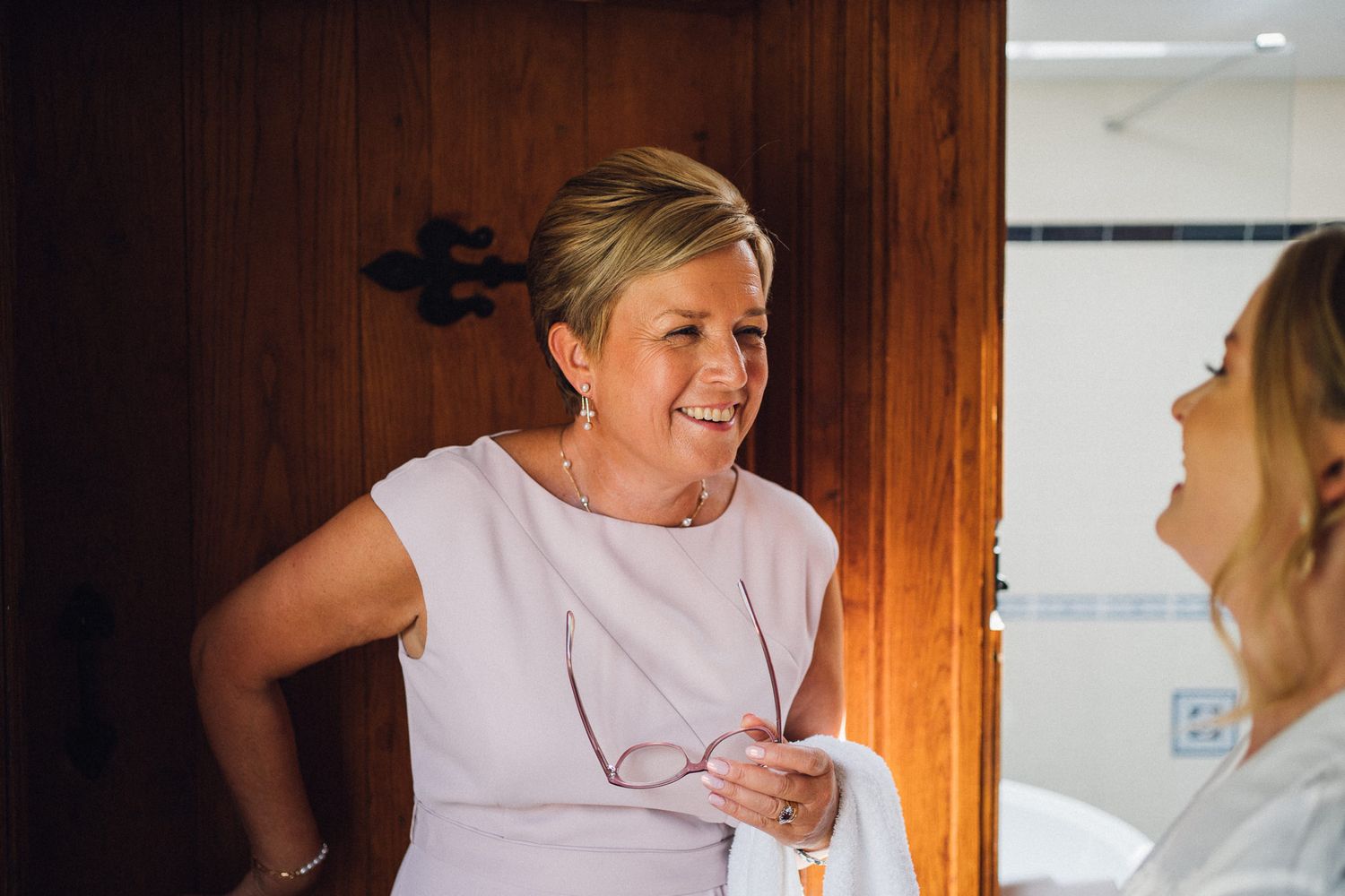 Candid moments captured during wedding day preparations in warm lighting.