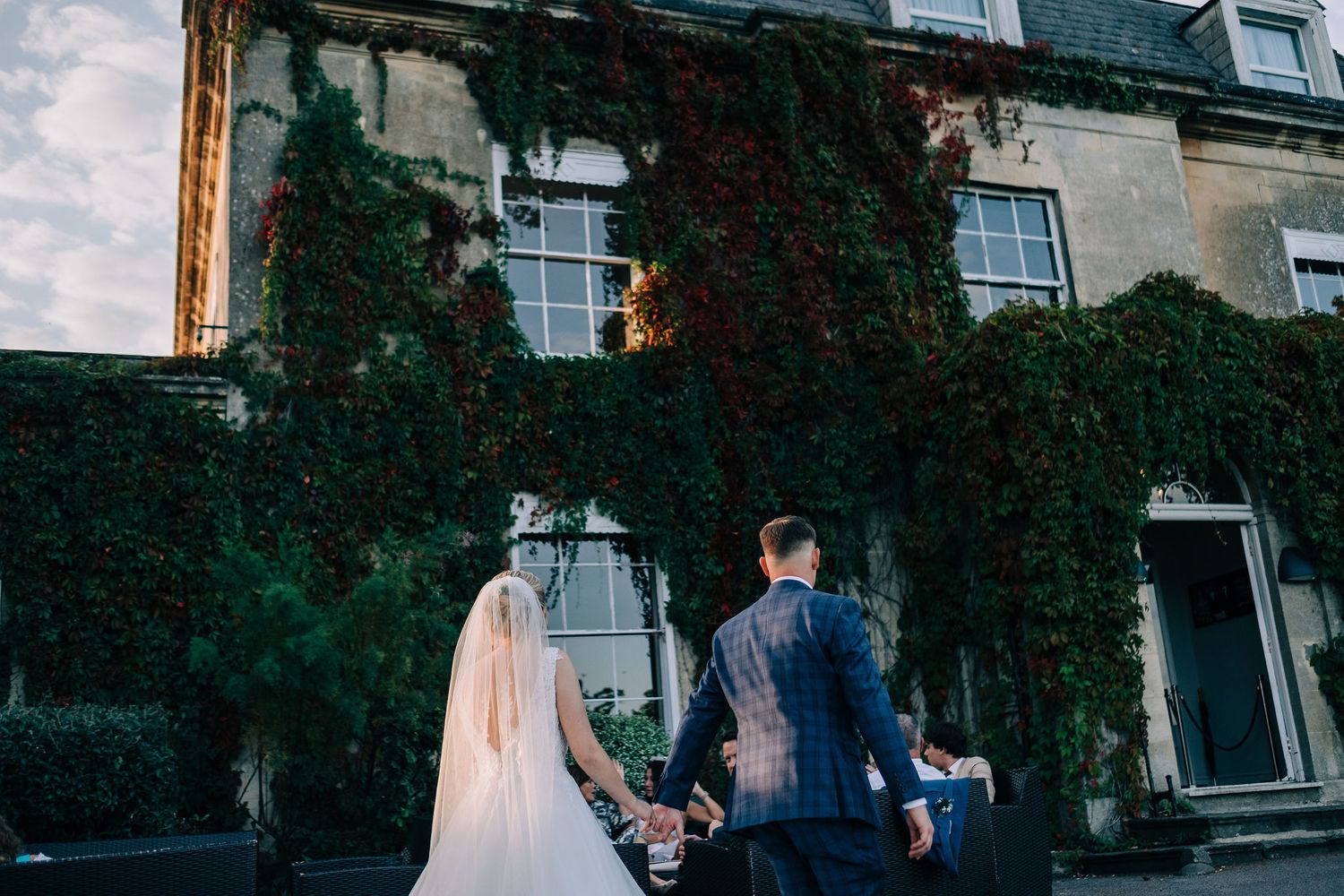 Historic stone building exterior with climbing ivy creates romantic wedding venue backdrop.