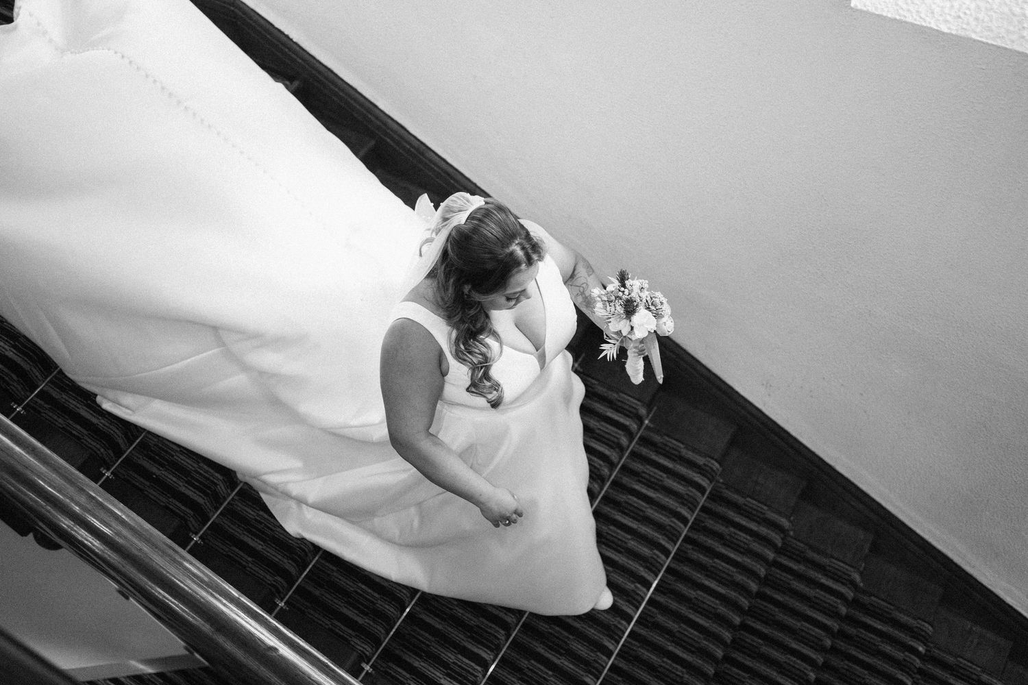 Close-up view of a white wedding dress against a dark background with dramatic lighting.