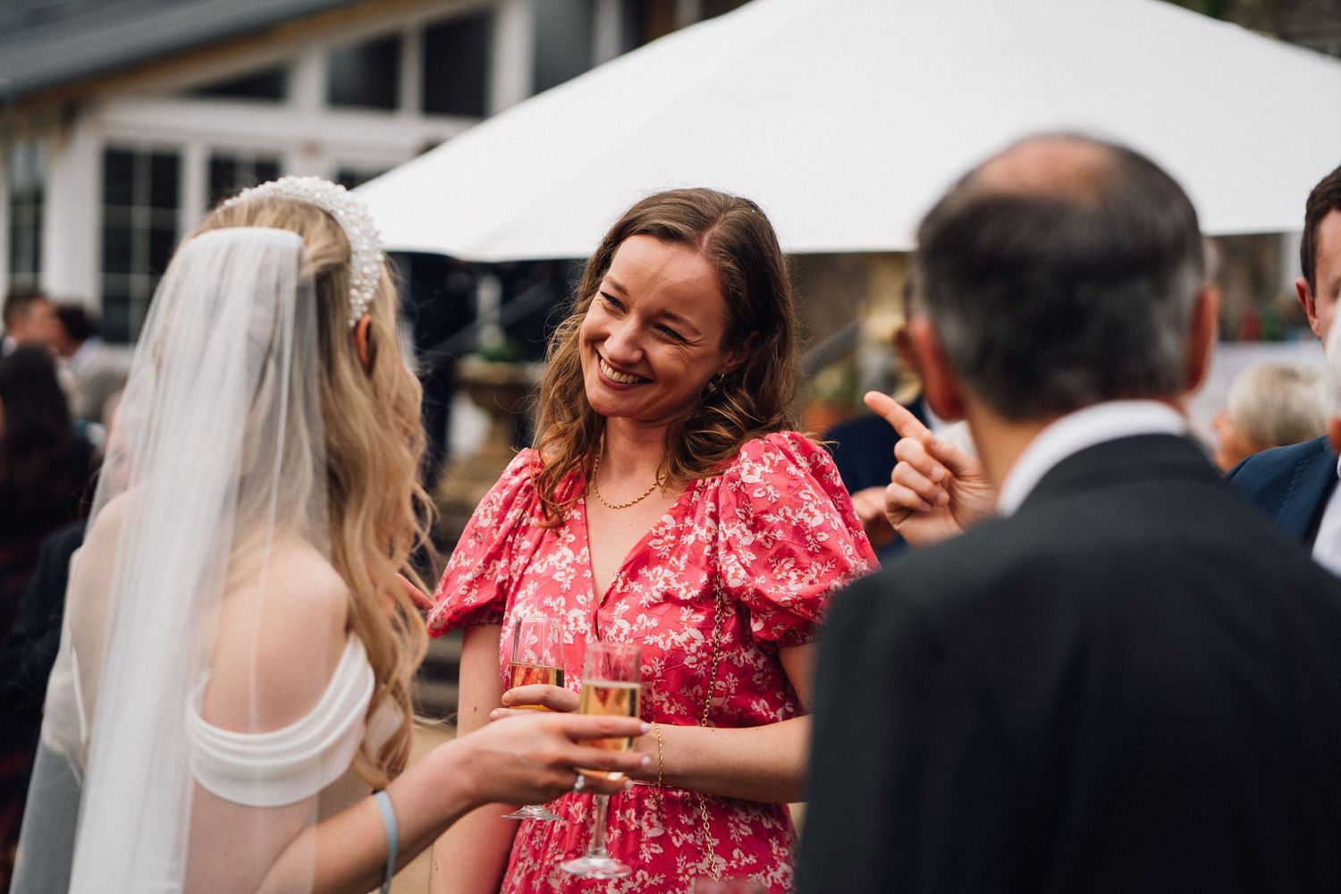 Wedding guests dance and celebrate on the dance floor at an indoor reception venue.