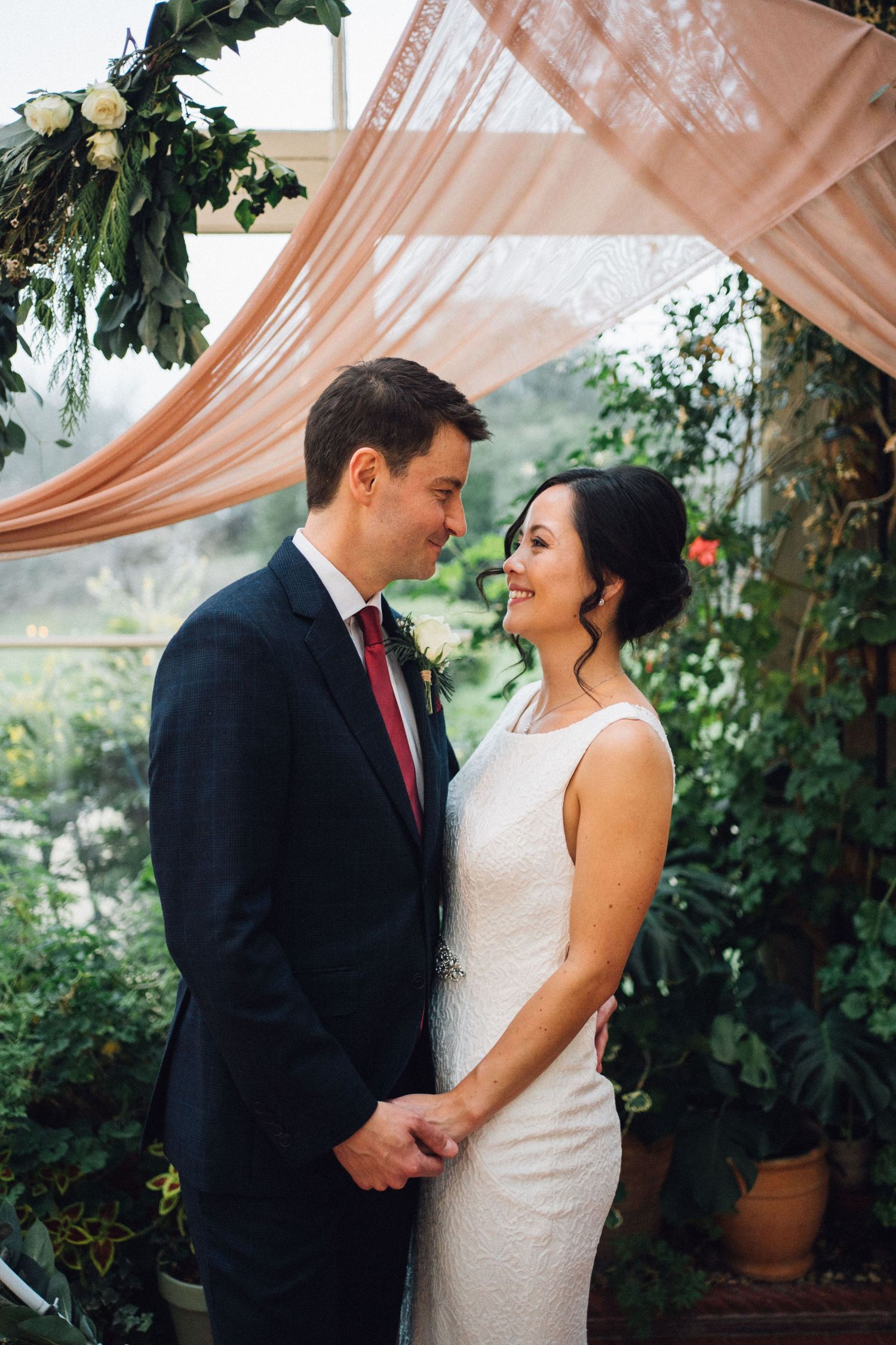 Romantic wedding photography sequence under peach drapes with garden backdrop.