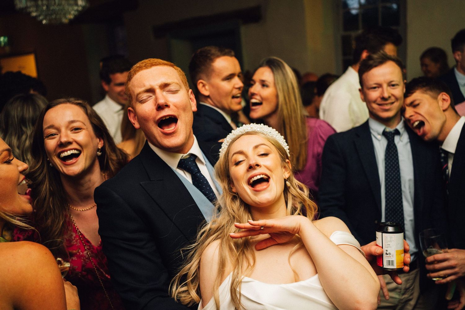 Candid moment of wedding guests laughing and celebrating during the reception.