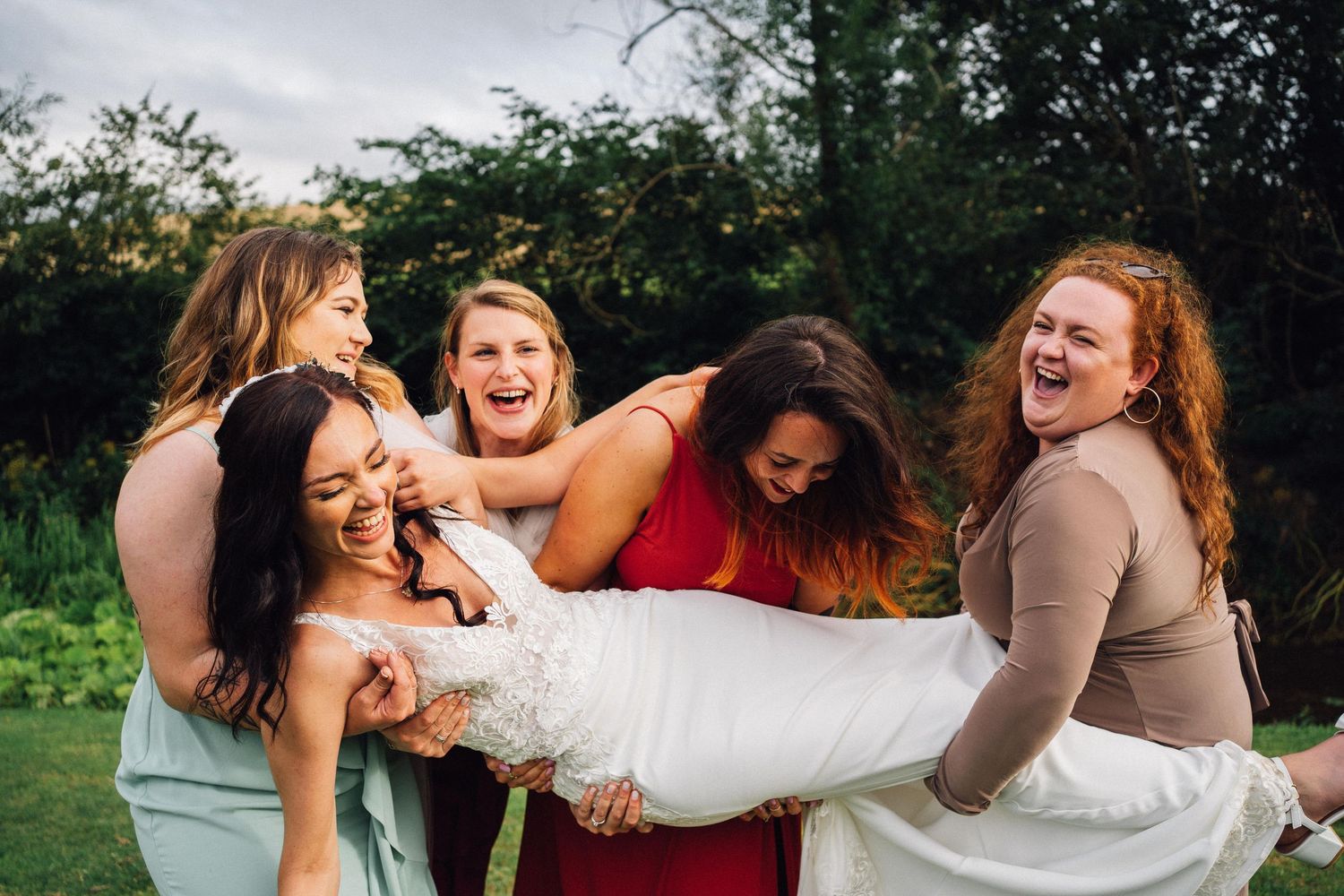 Joyful wedding celebration moments with guests laughing and embracing outdoors.