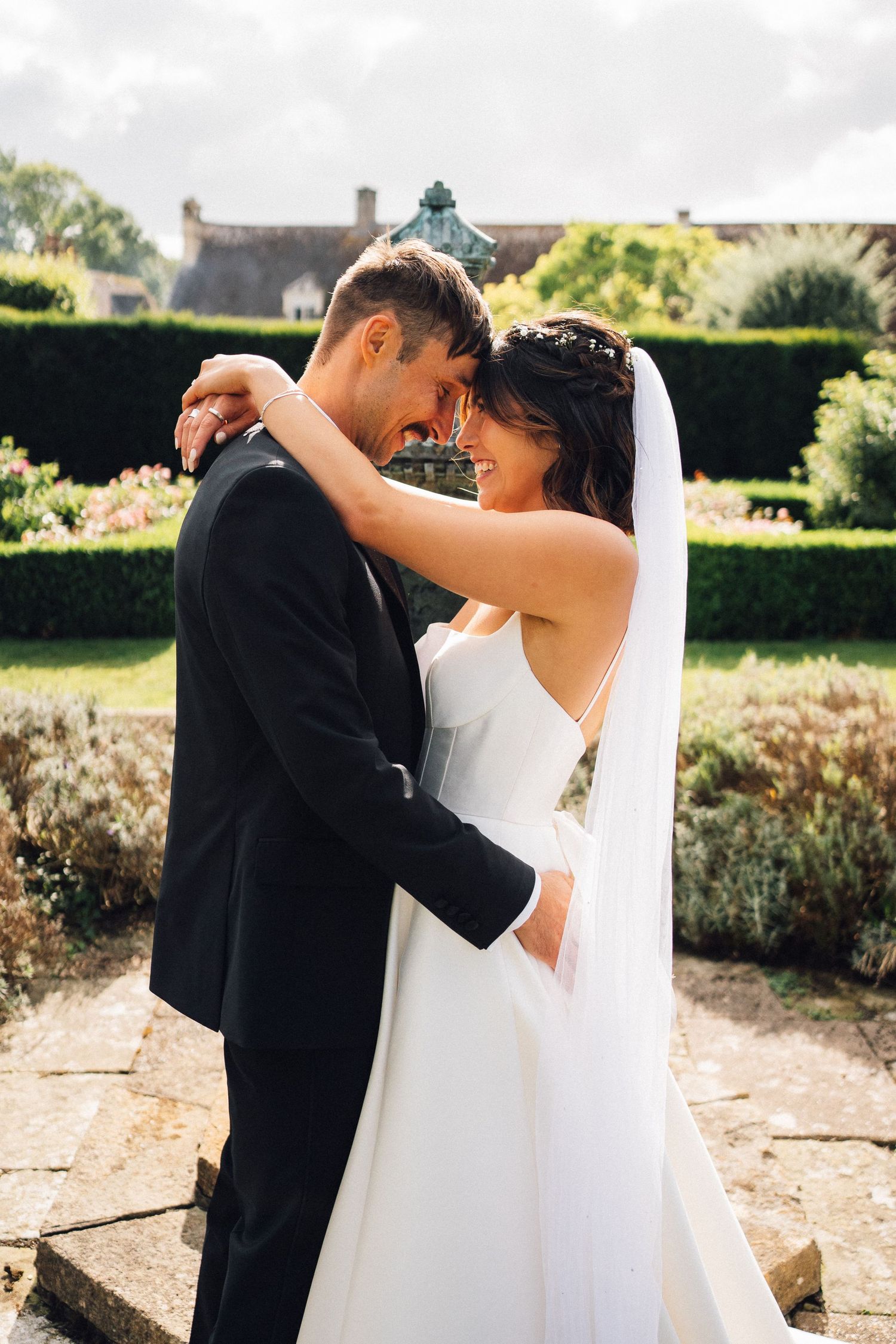 Wedding couple sharing a romantic dance moment in an outdoor garden setting.