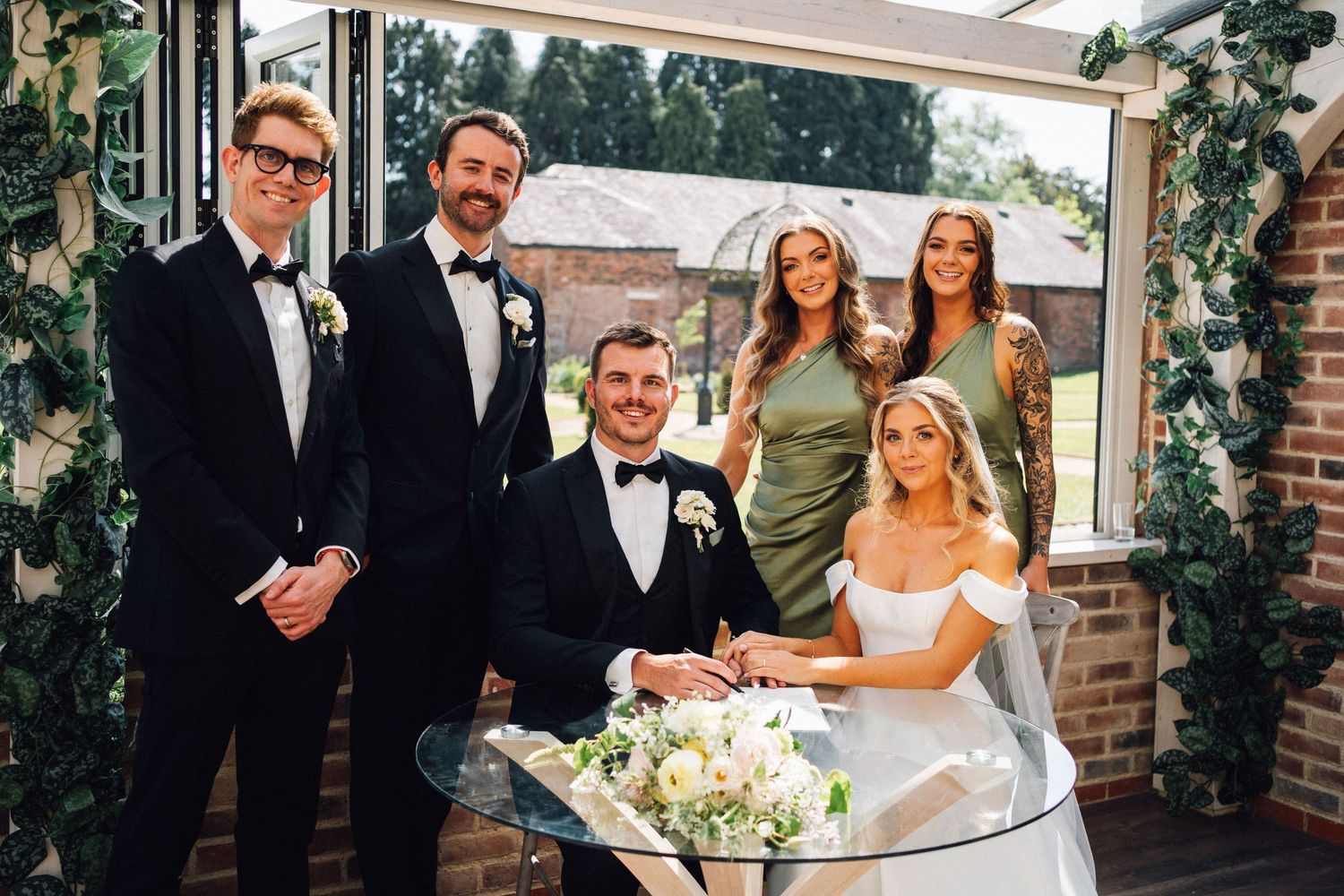 Wedding celebration scene with formal attire and joyful toasts during an outdoor ceremony.