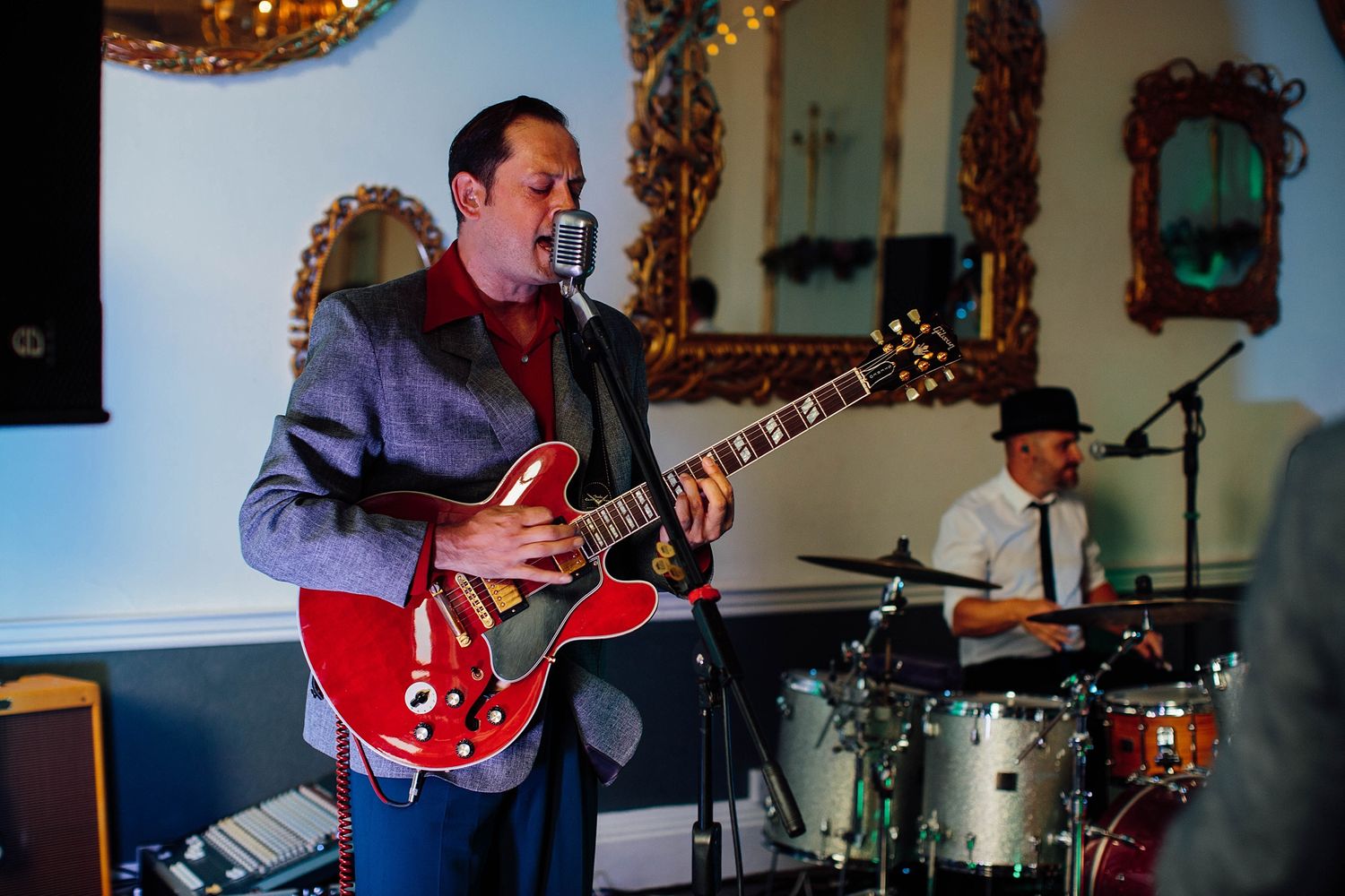 Band performing live music with guitars and instruments at a wedding reception.