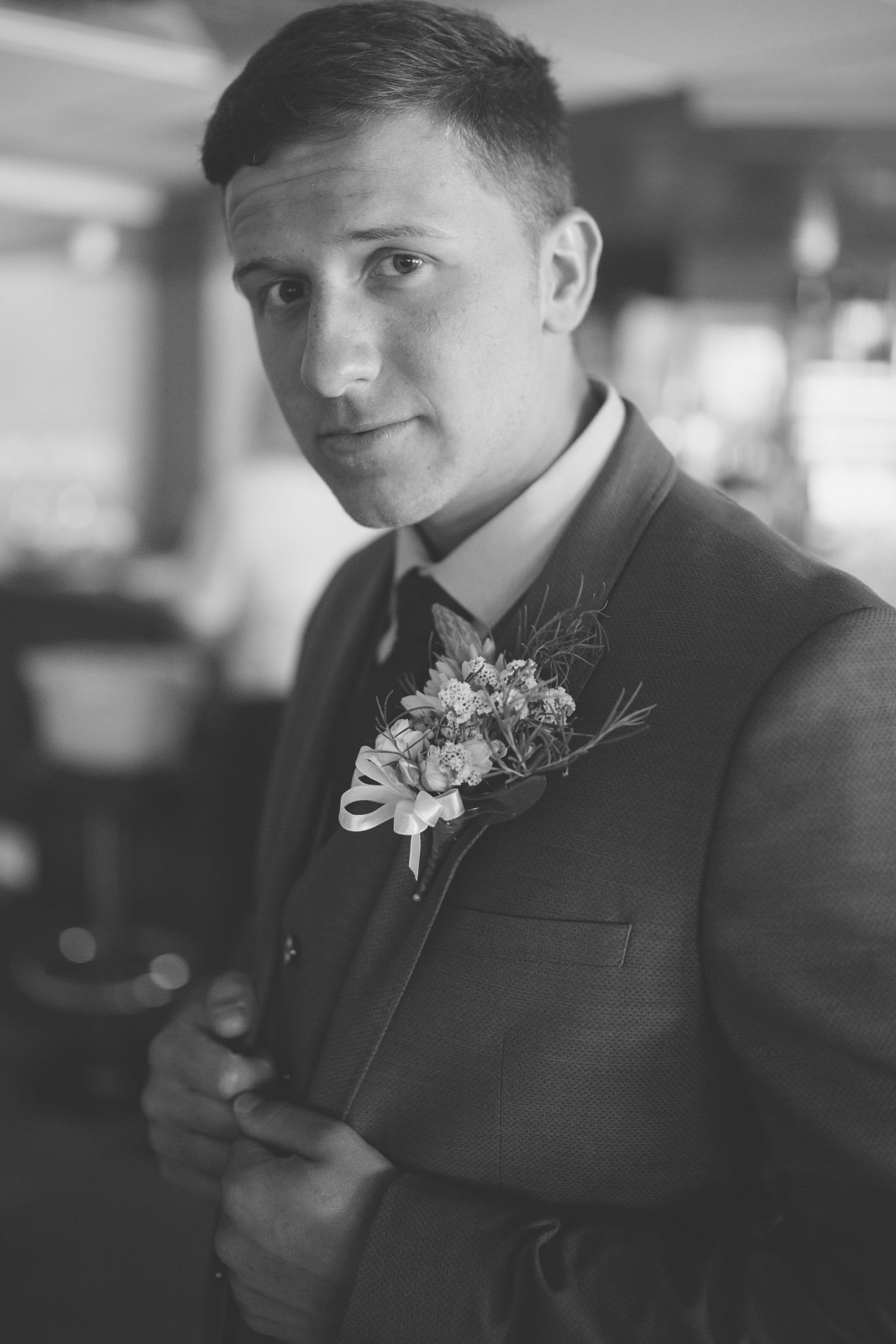 Black and white portraits of groomsmen wearing boutonnieres and formal suits.