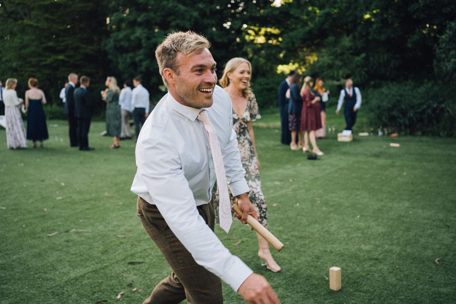Wedding guests playing lawn games at an outdoor summer reception.