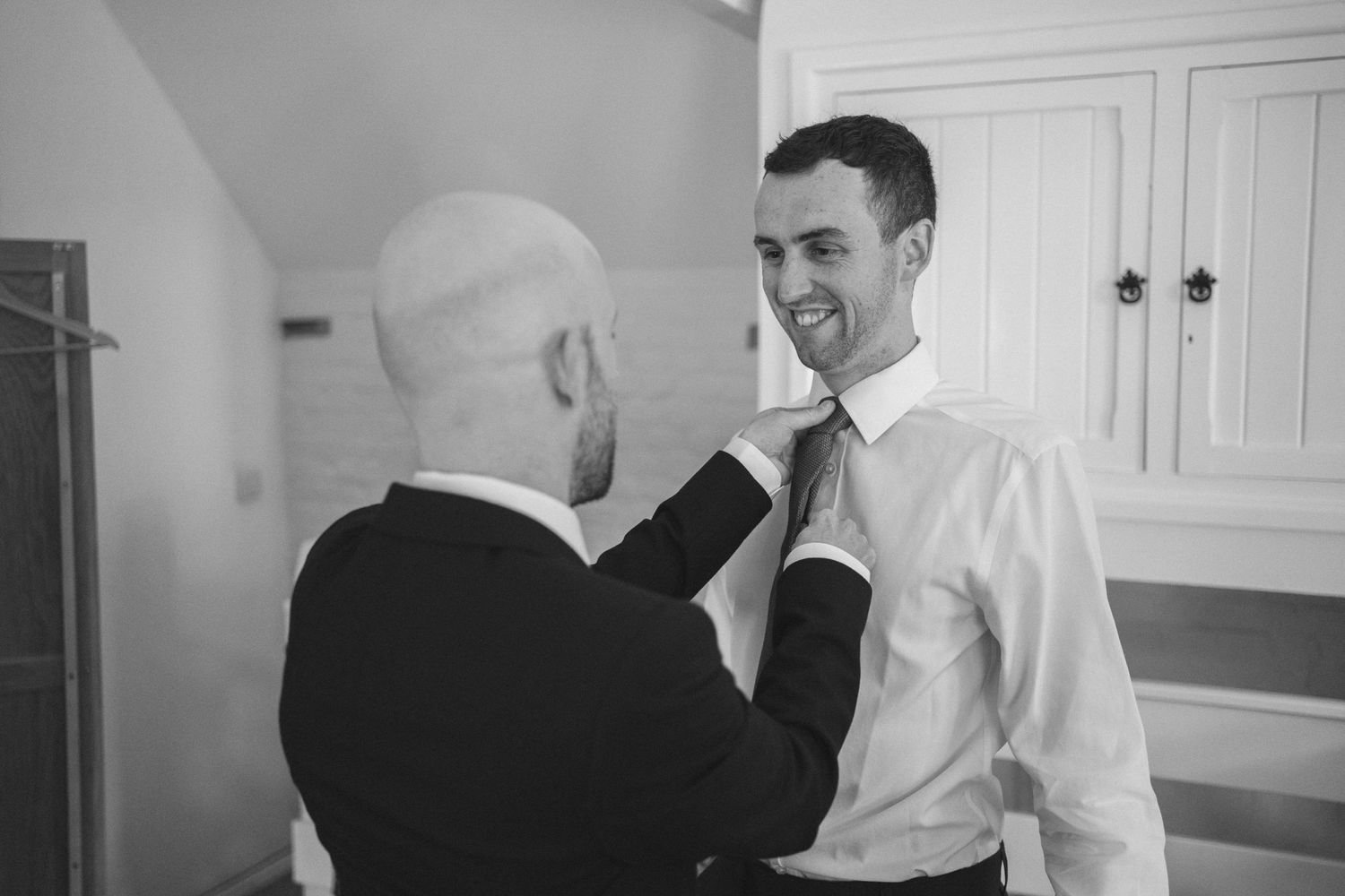 Black and white candid photographs of people interacting in a bright interior space.