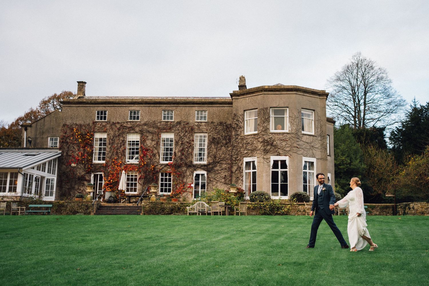 A panoramic view of a historic English manor house with multiple connected images showing the exterior and grounds.