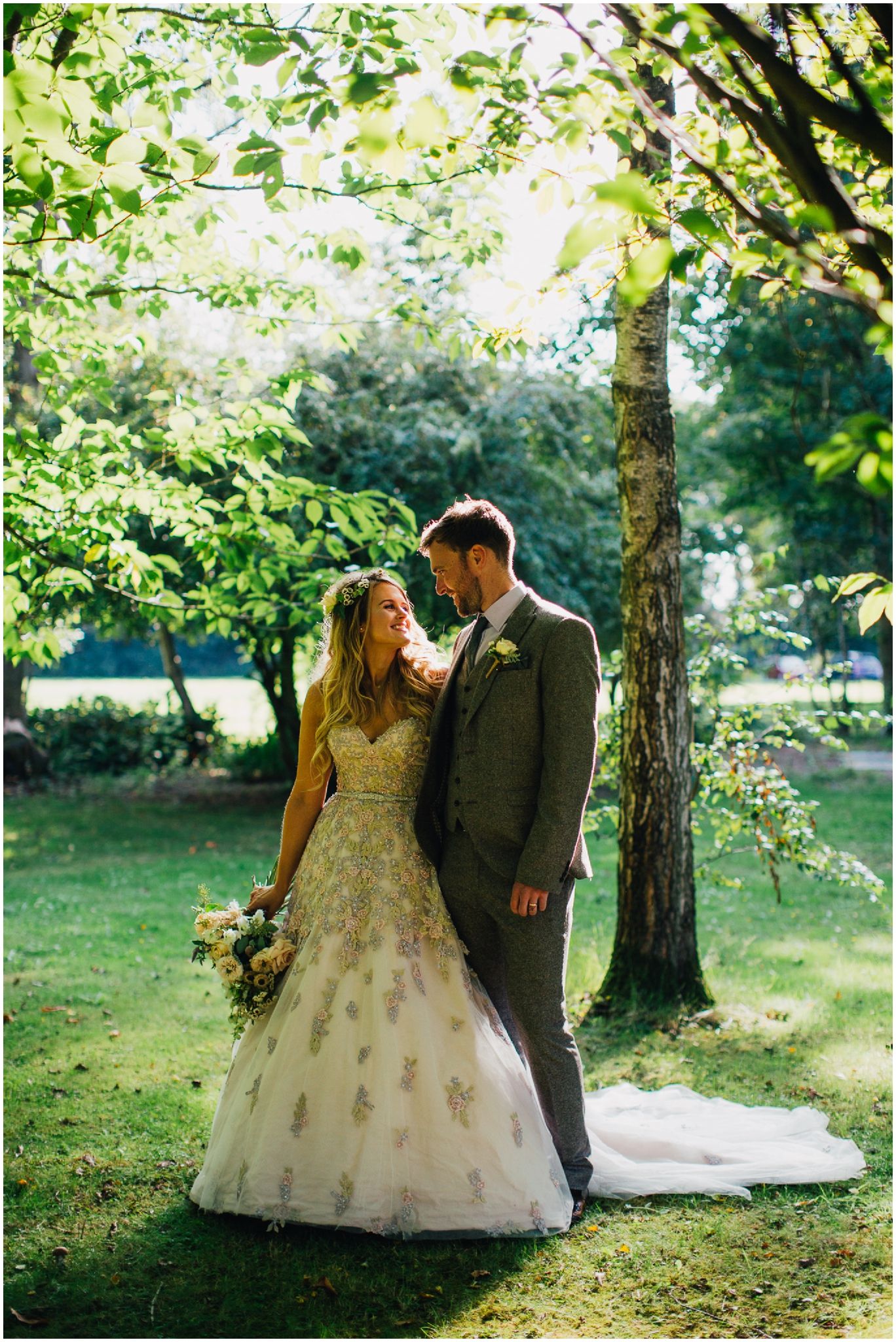 Romantic garden wedding portraits under trees with natural sunlight filtering through.