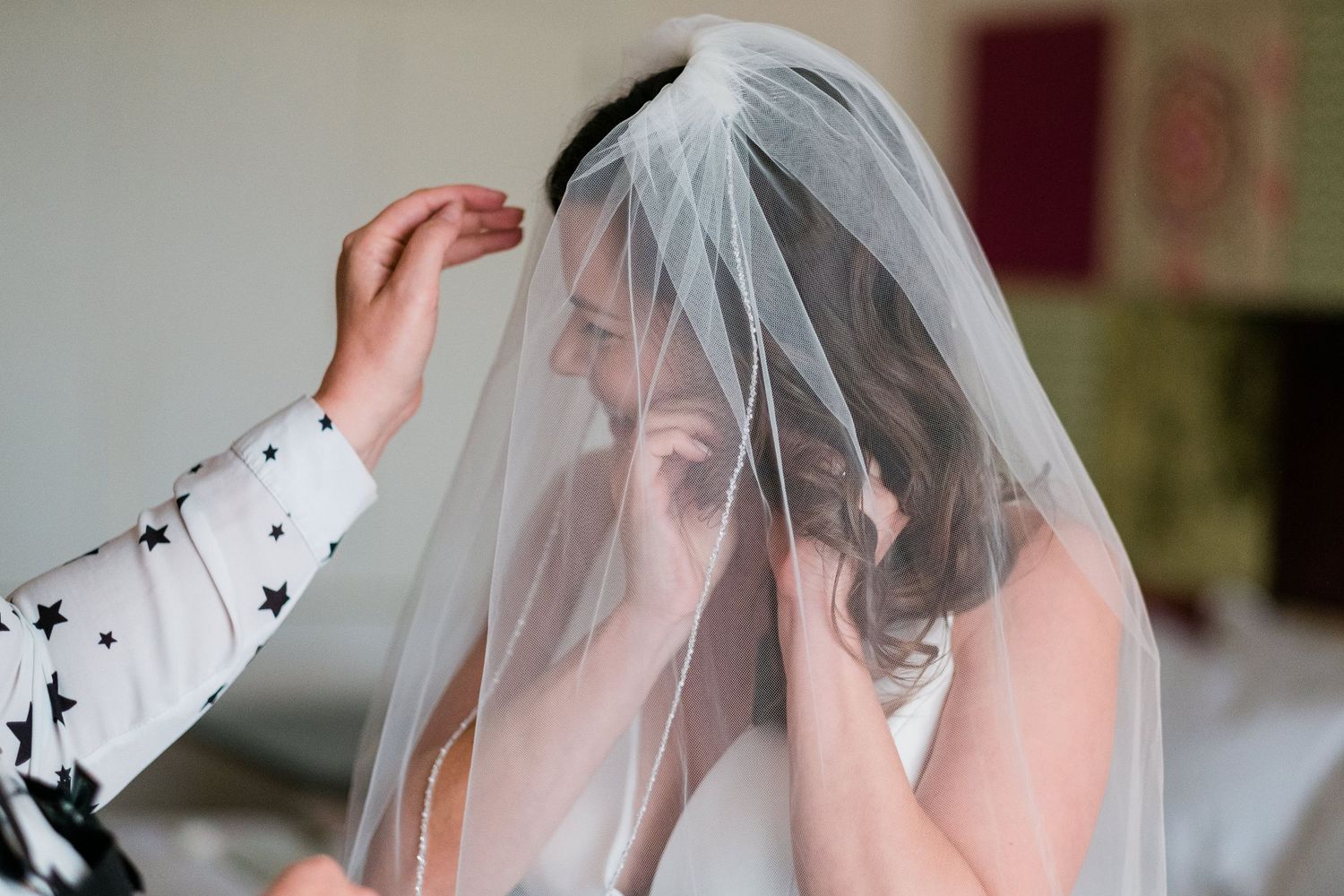 Wedding veil adjustments and final touches being made during bridal preparation.