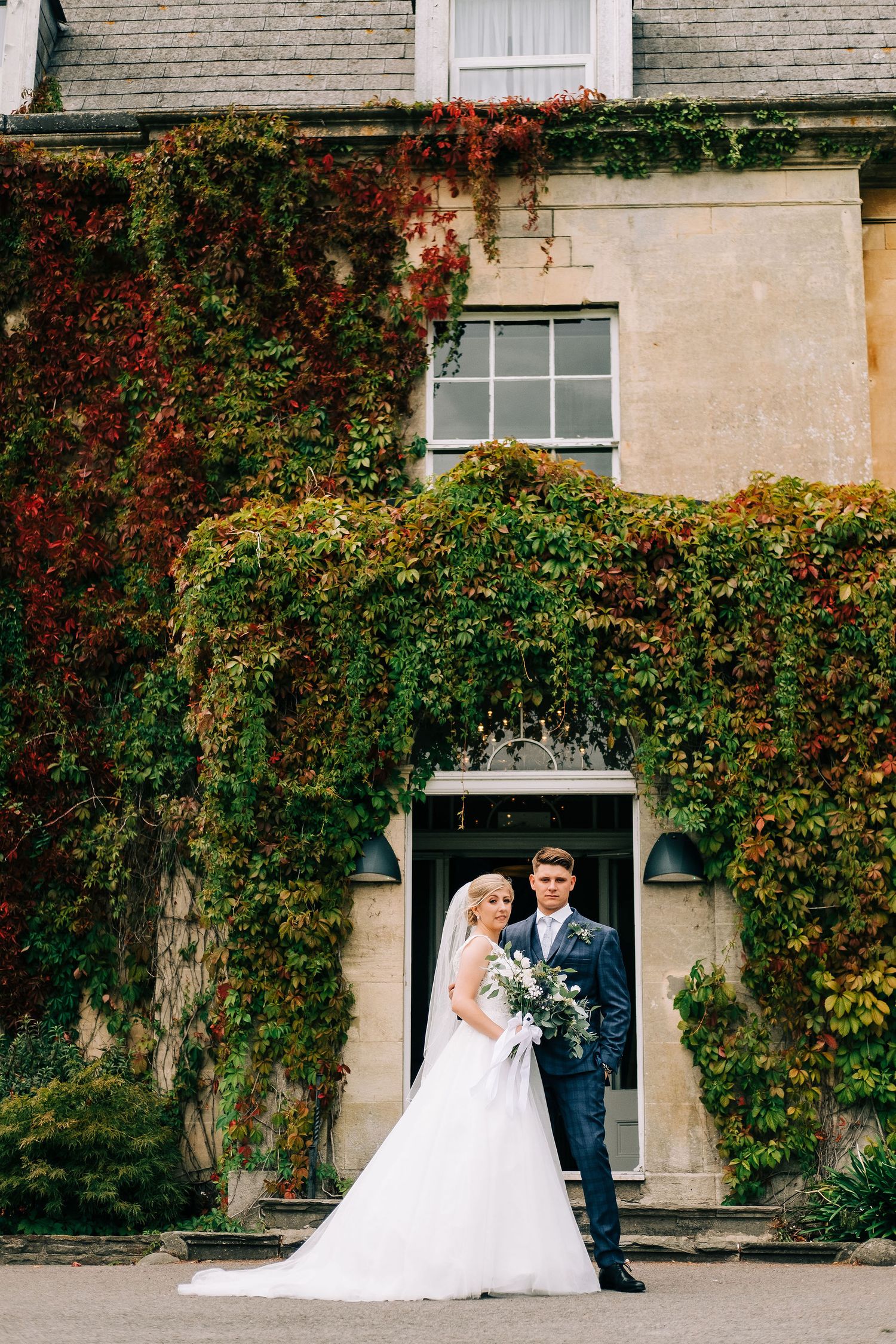 Wedding portraits captured against historic ivy-covered stone building.