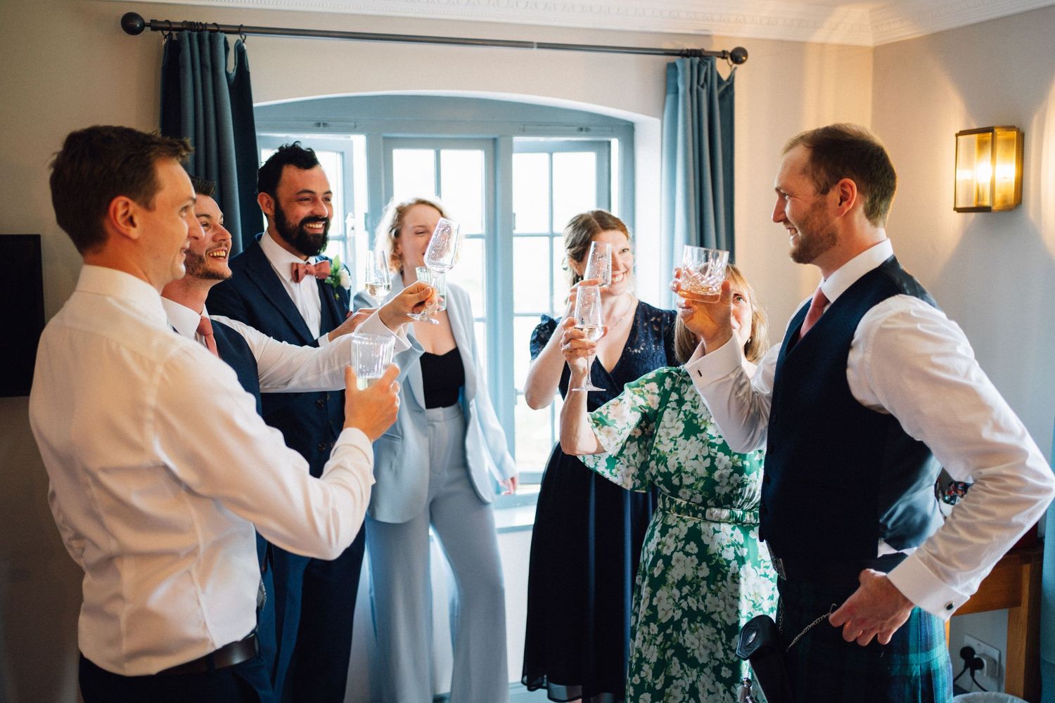 Wedding party members sharing joyful moments during pre-ceremony preparations.