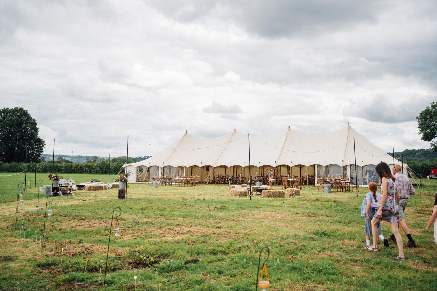 A series of scenic images showing a historic fort site with tents, grassy fields, and wooden structures in the background.