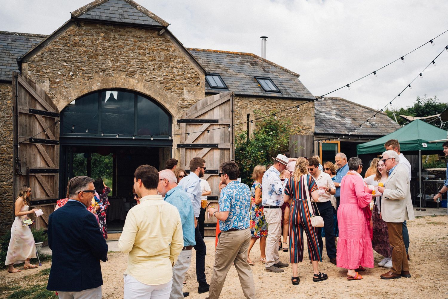 Stone barn exterior with guests gathering outside during an event.