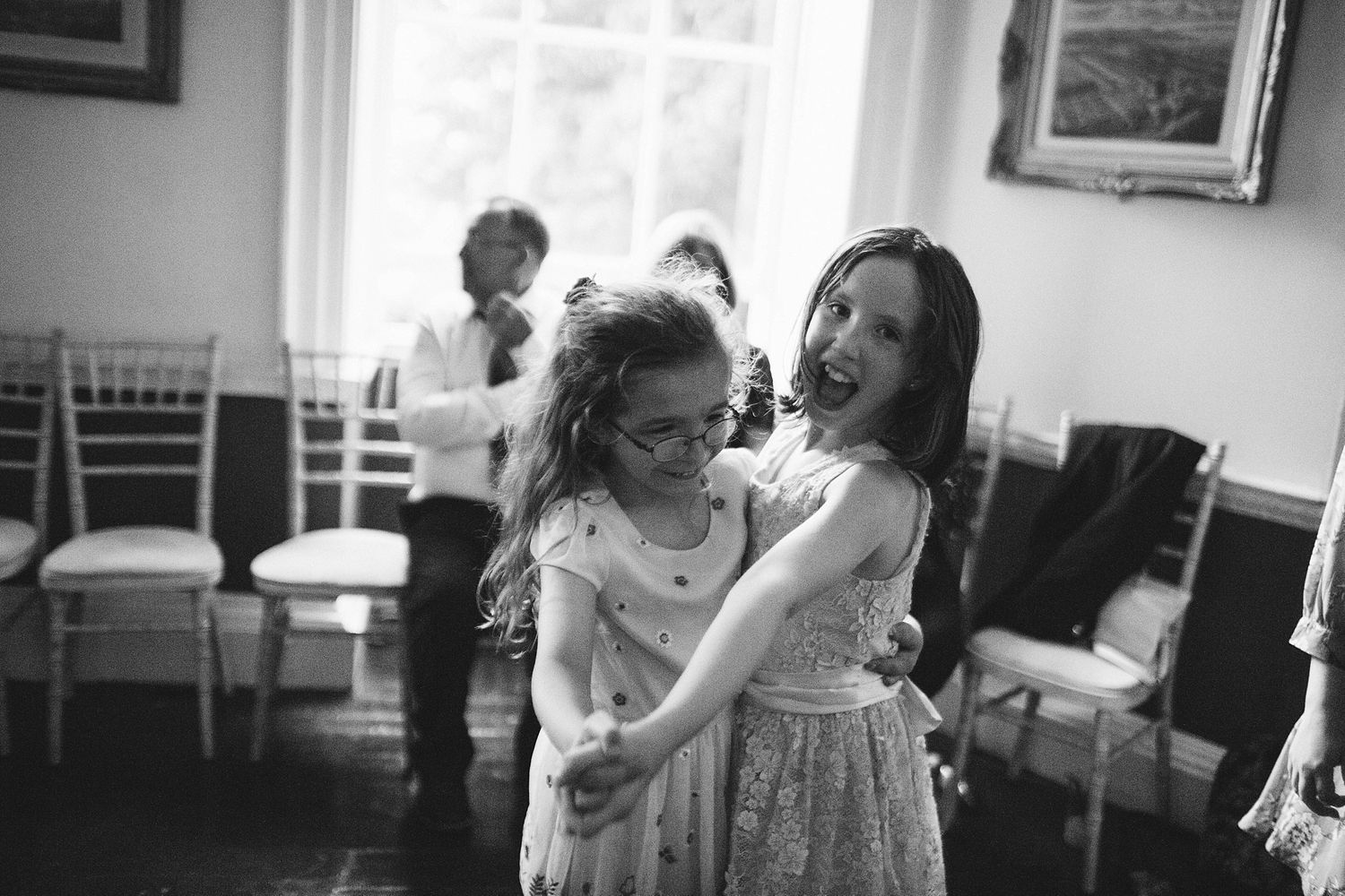 Black and white candid shots of wedding guests sharing intimate moments.