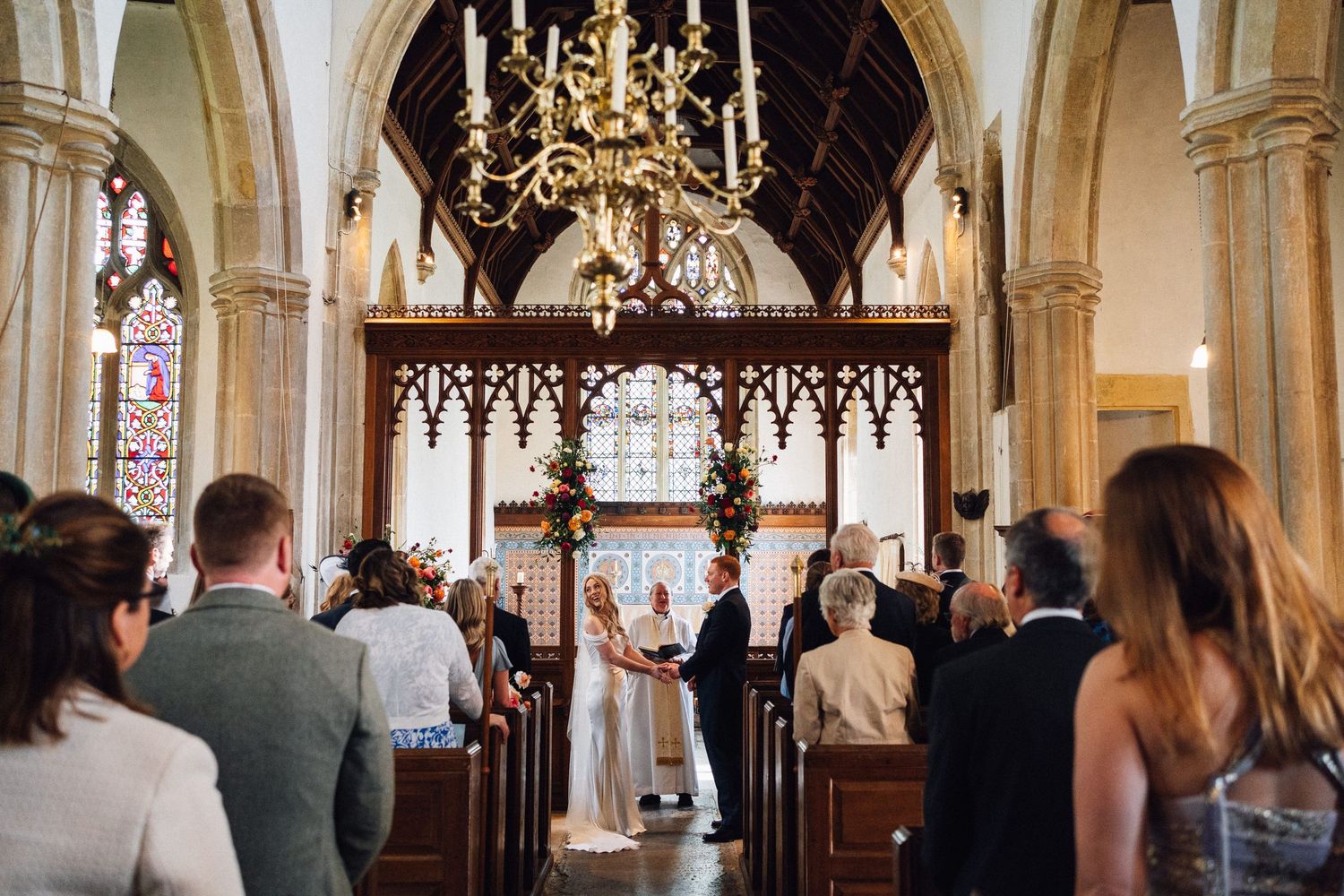 Interior of historic church with arched ceilings and elegant chandeliers during ceremony.