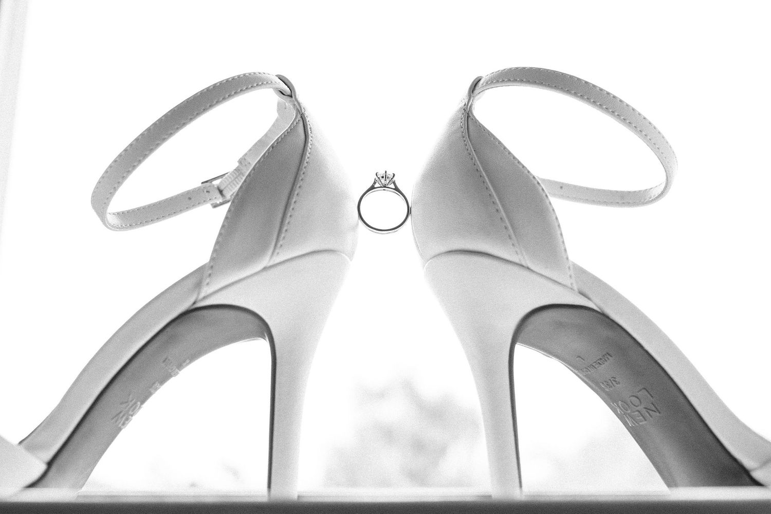 Multiple pairs of elegant silver bridal shoes arranged in a row.