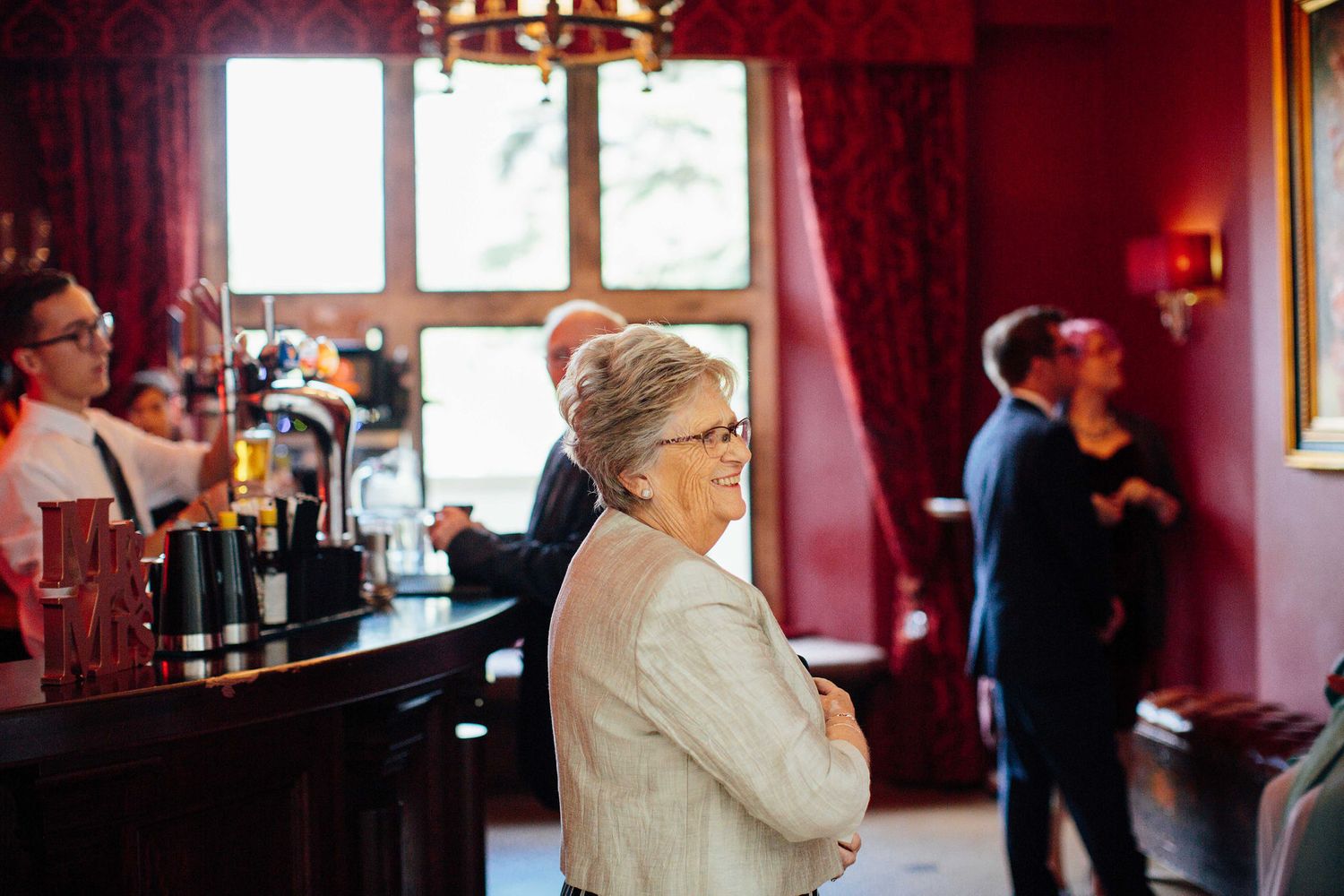 Interior of a venue with deep red walls and guests mingling during an event.