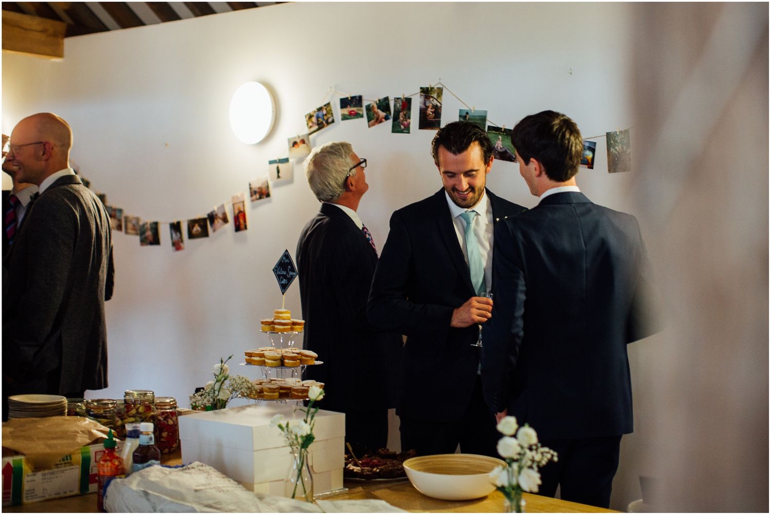 Wedding guests mingling in a bright indoor reception space.