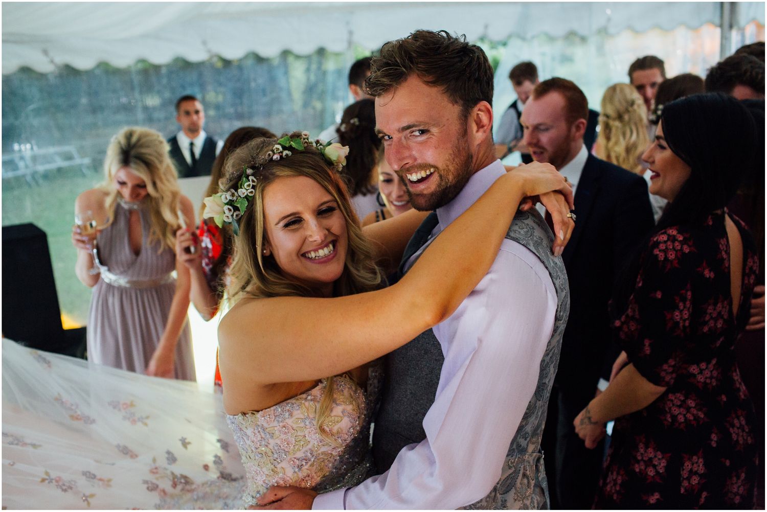 Couples dancing closely together during romantic moments at a wedding reception.