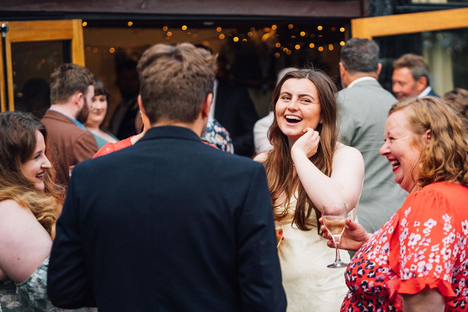 People dancing and celebrating at a lively party with warm lighting and festive atmosphere.