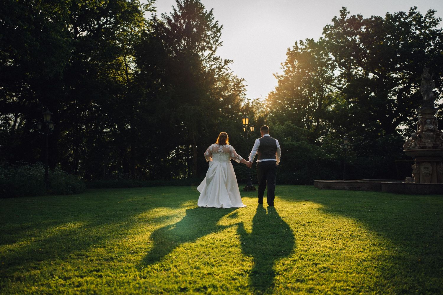 Silhouettes of people against a golden sunset in a grassy field.