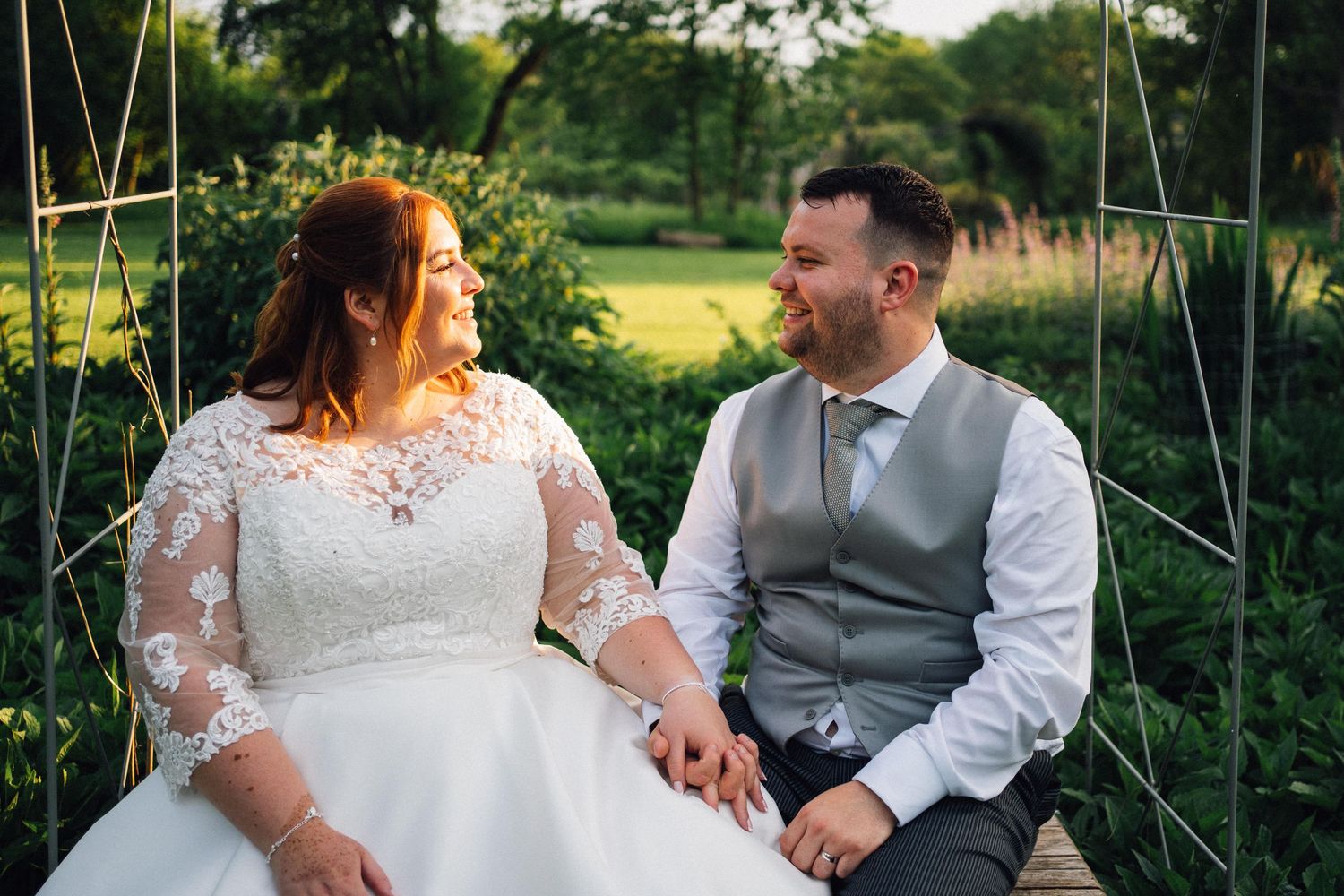 Romantic outdoor wedding photo session in a lush green garden setting.