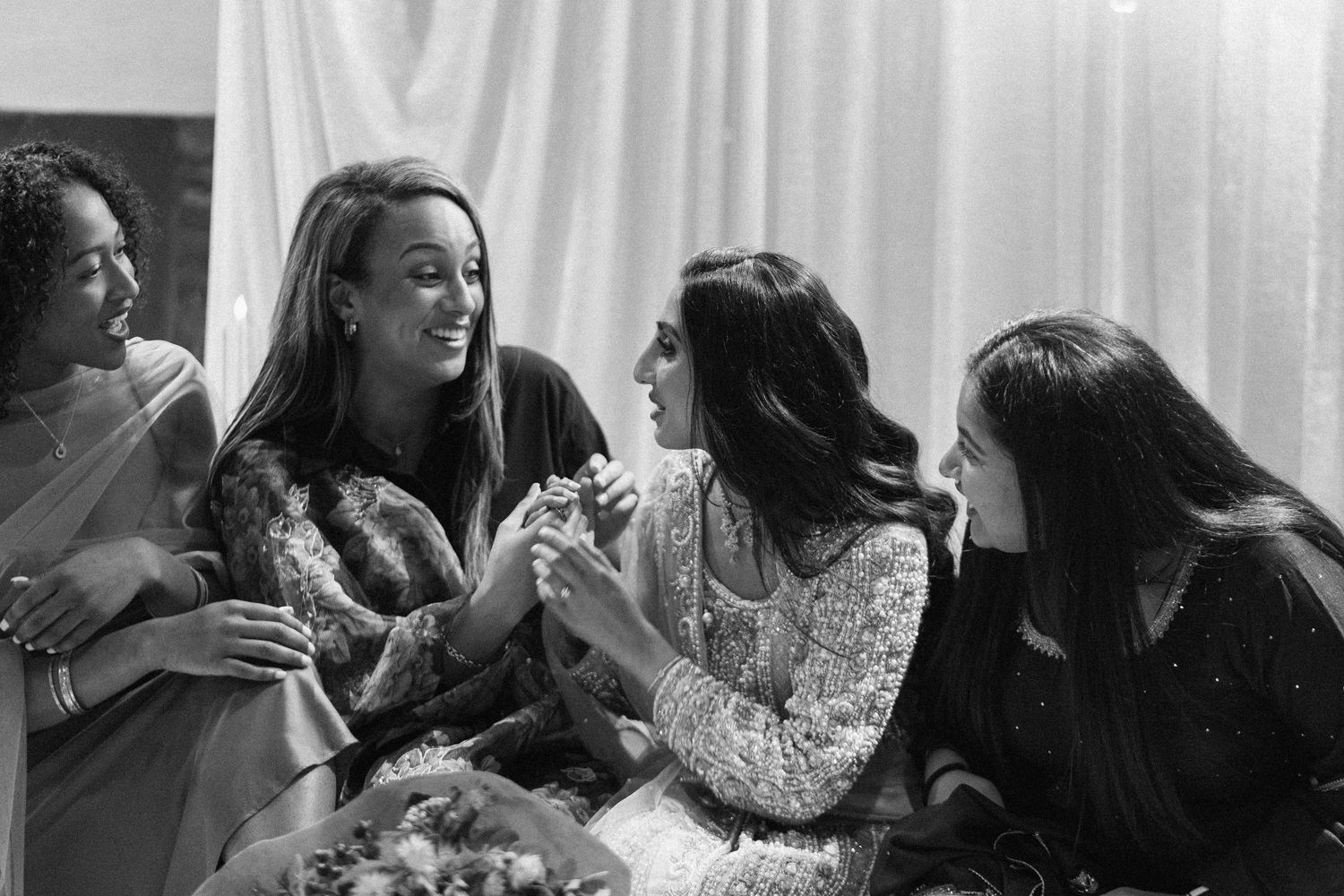 Wedding guests celebrating and interacting at a reception with white backdrop.