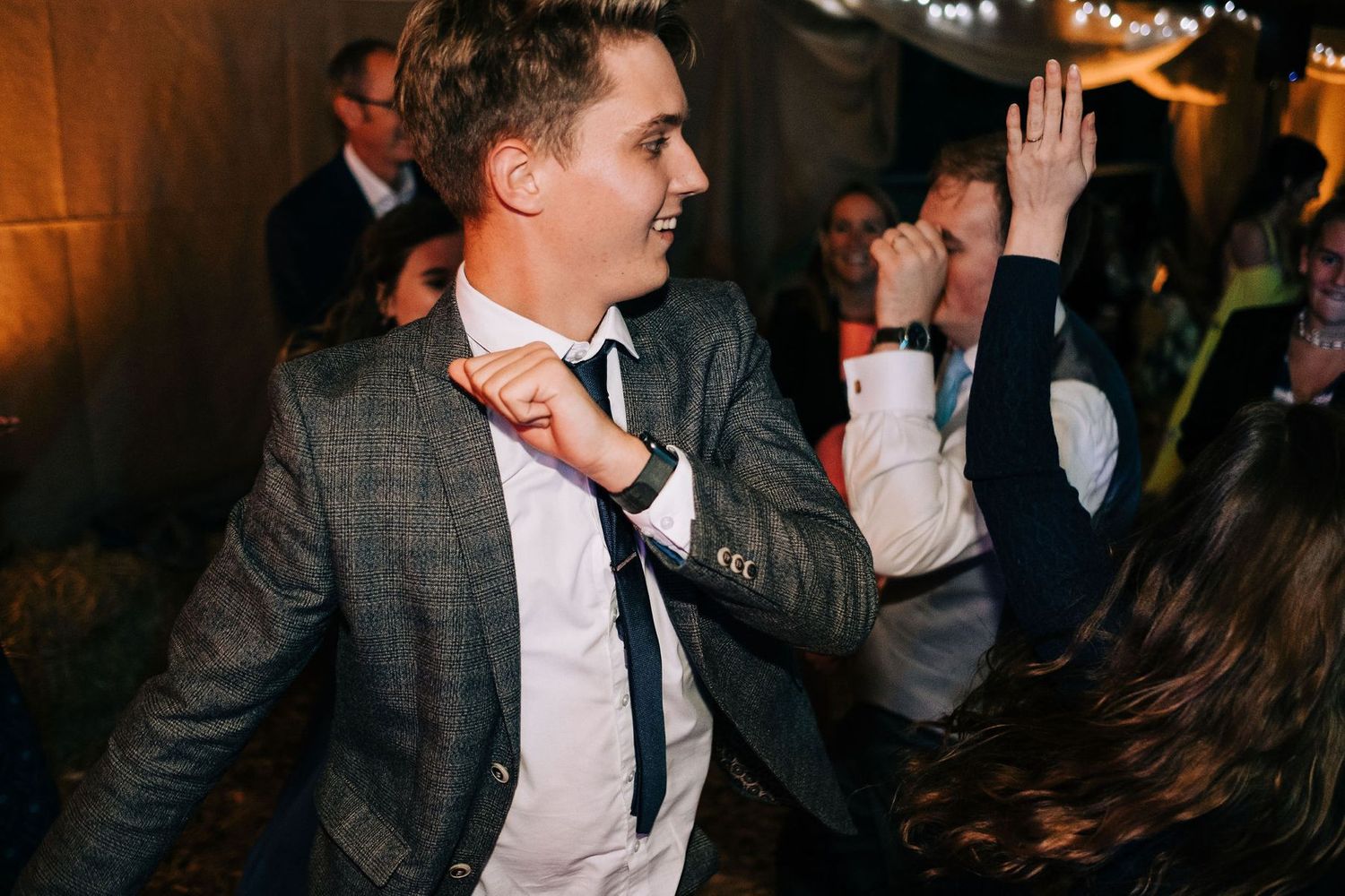 Guests in formal attire dancing and celebrating at an evening wedding reception.