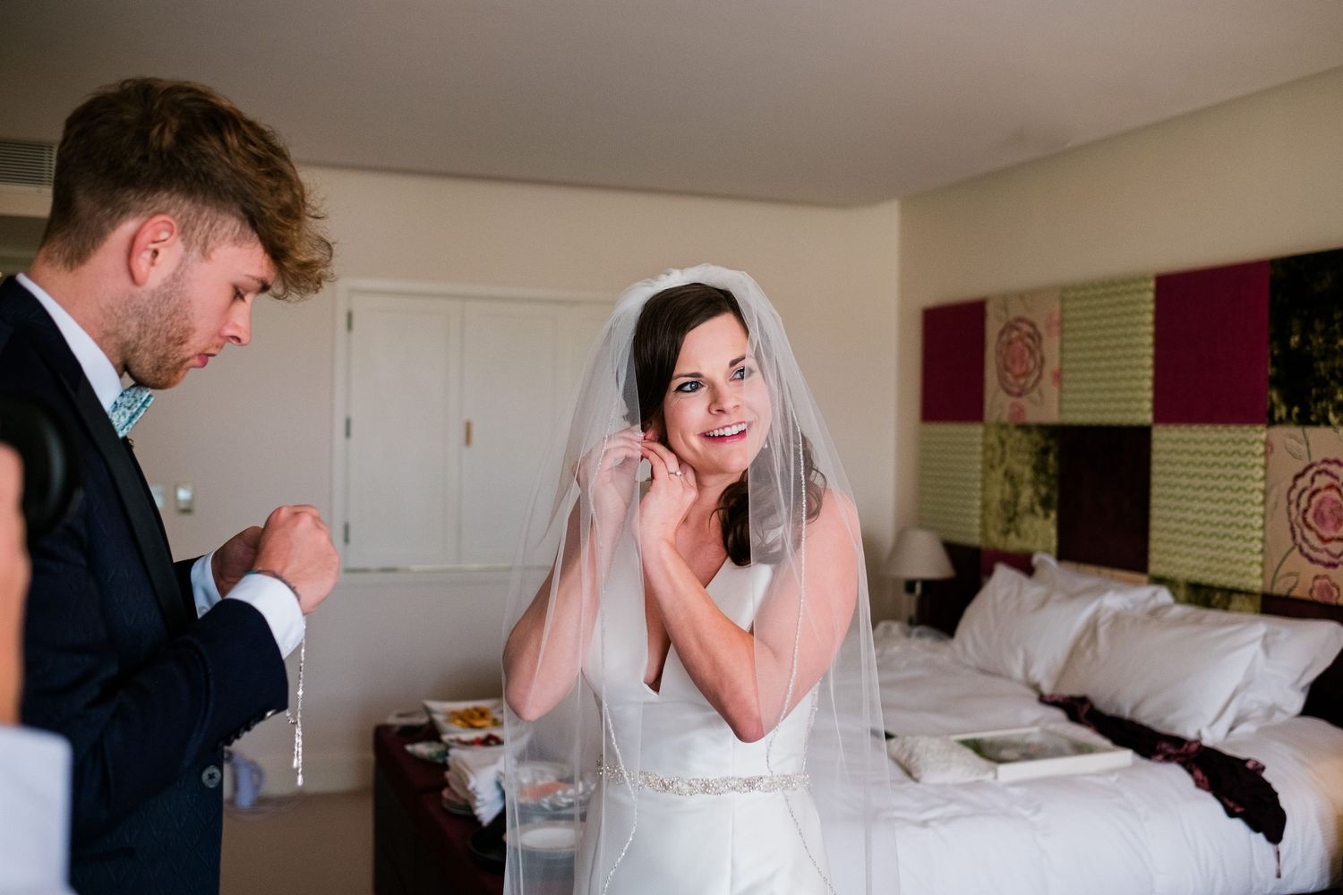 Candid moments captured during wedding day preparations in a hotel room.