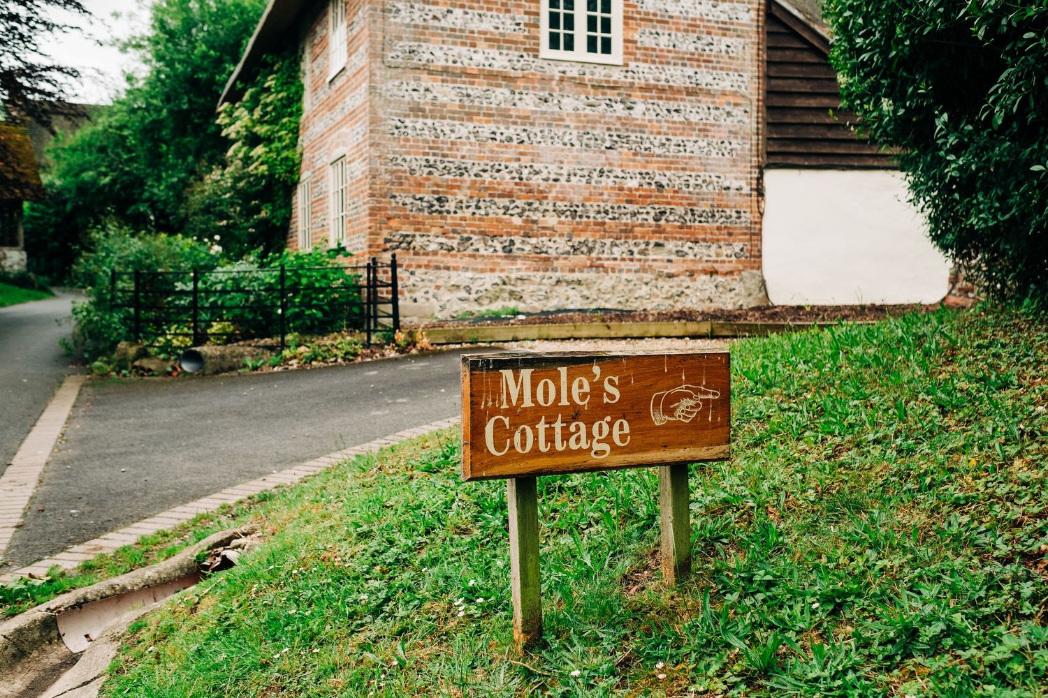 Rustic wooden signpost for cottages along a country path.
