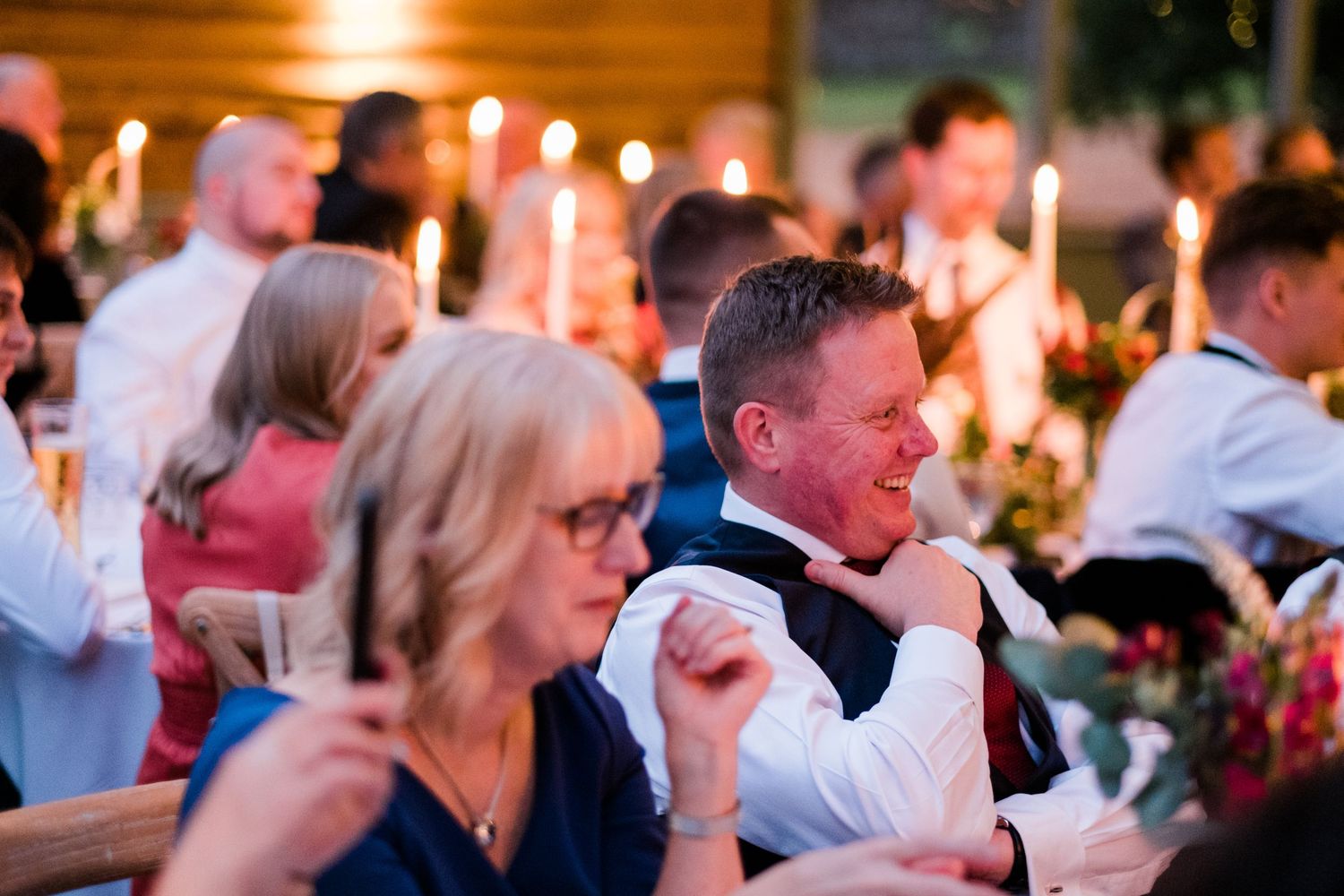 Evening wedding reception with guests celebrating under warm lighting.
