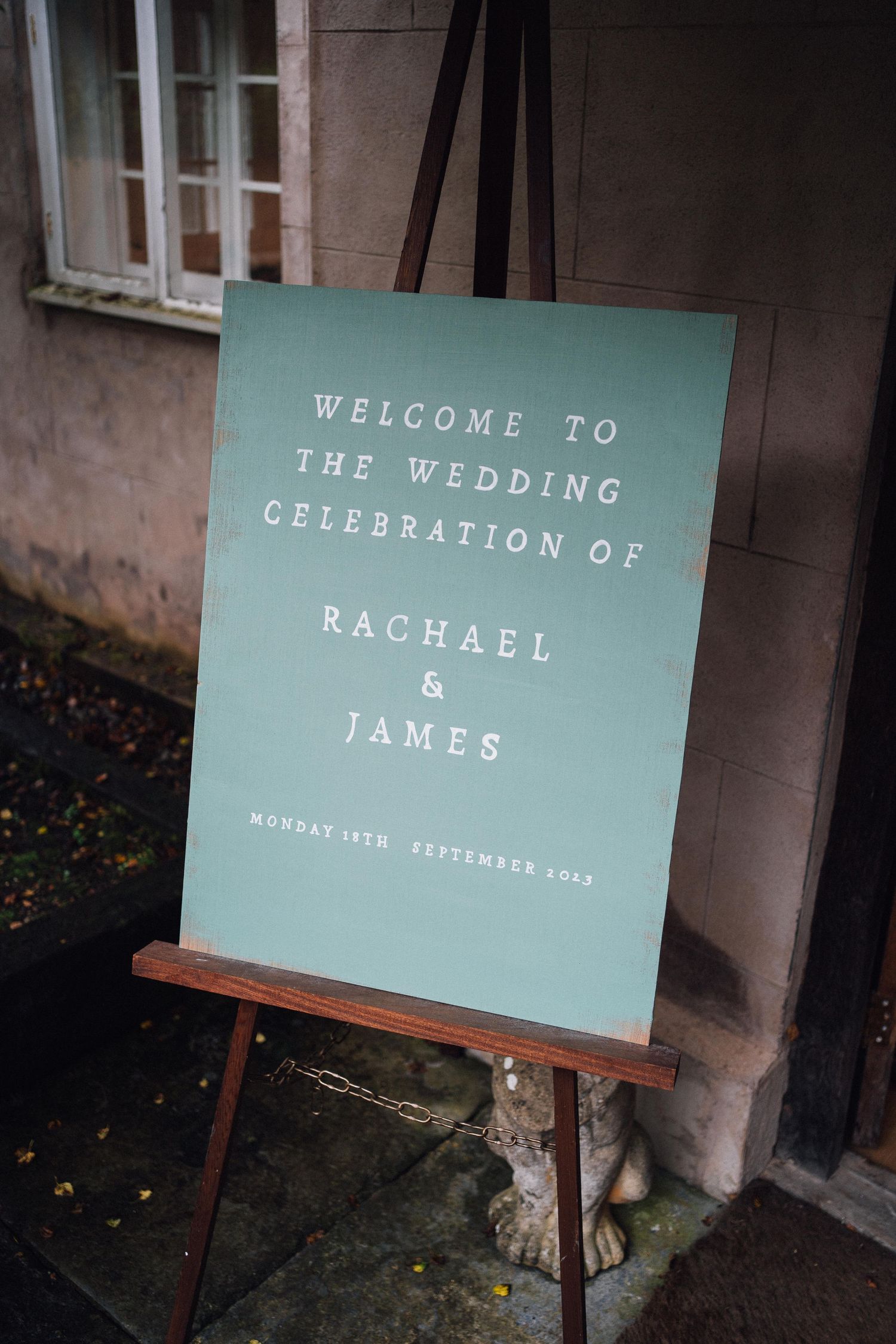 Mint green welcome signs for a wedding celebration displayed on wooden easels.