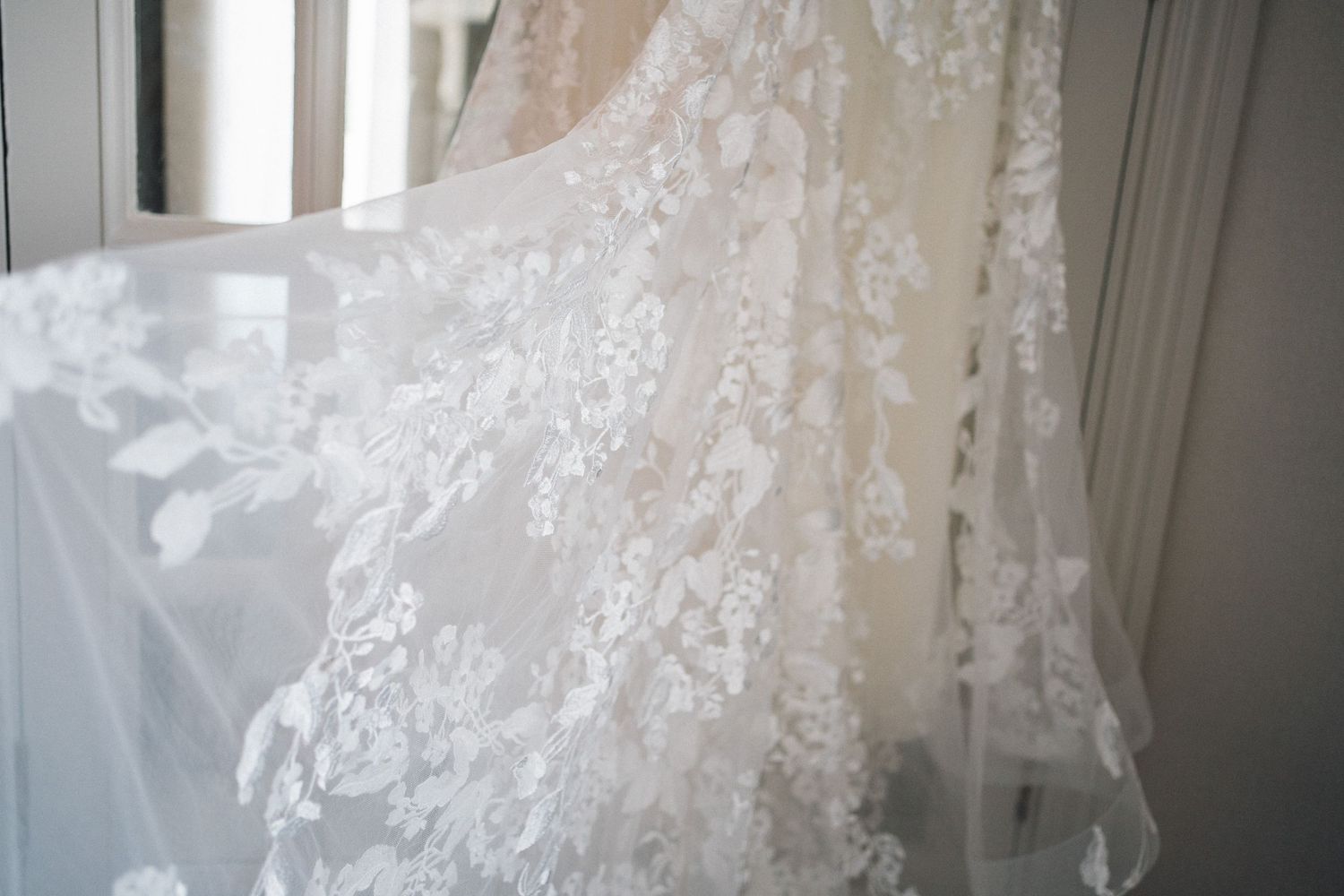 Close-up details of intricate lace patterns on a white wedding dress.