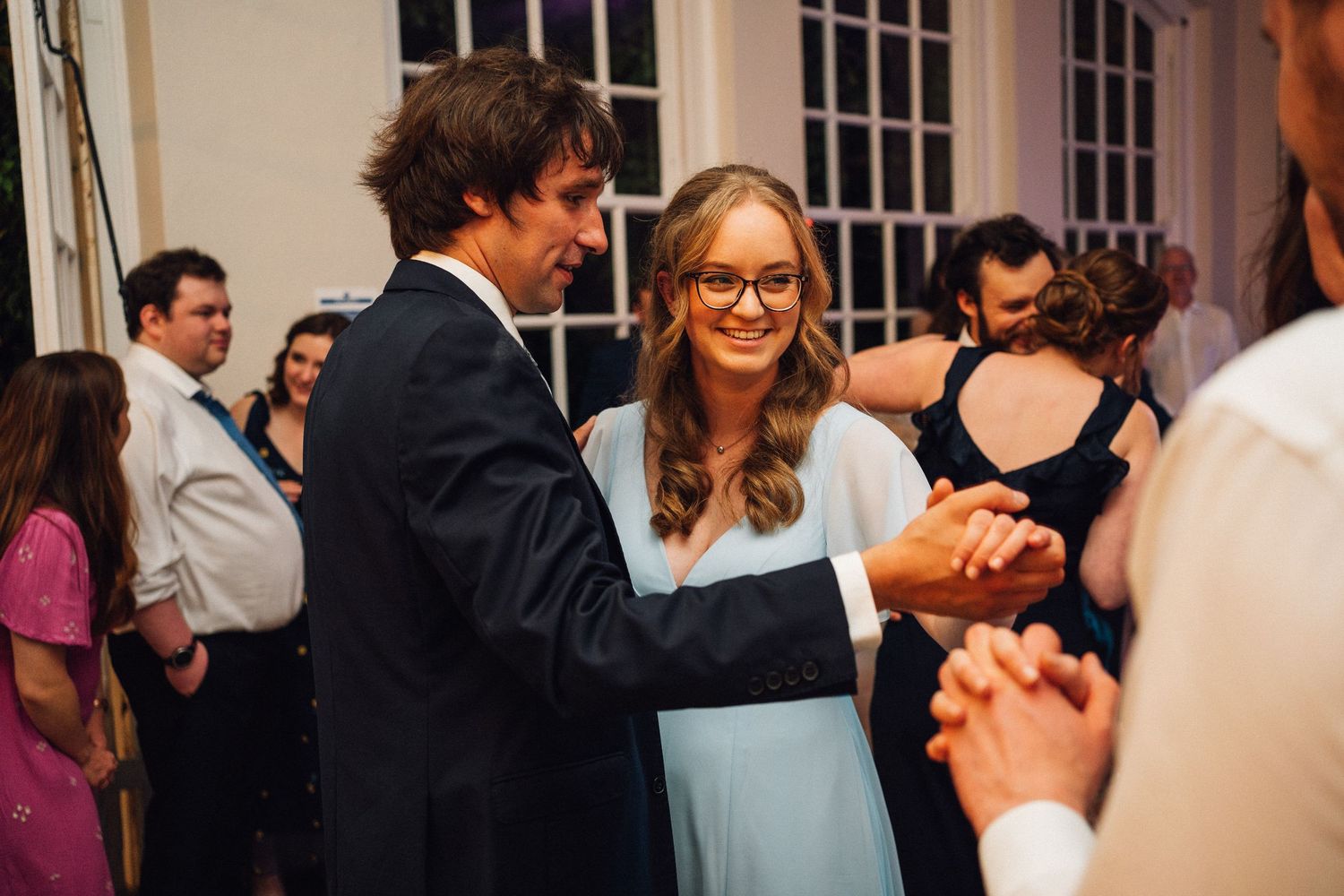 Wedding guests mingling and socializing during an indoor reception.