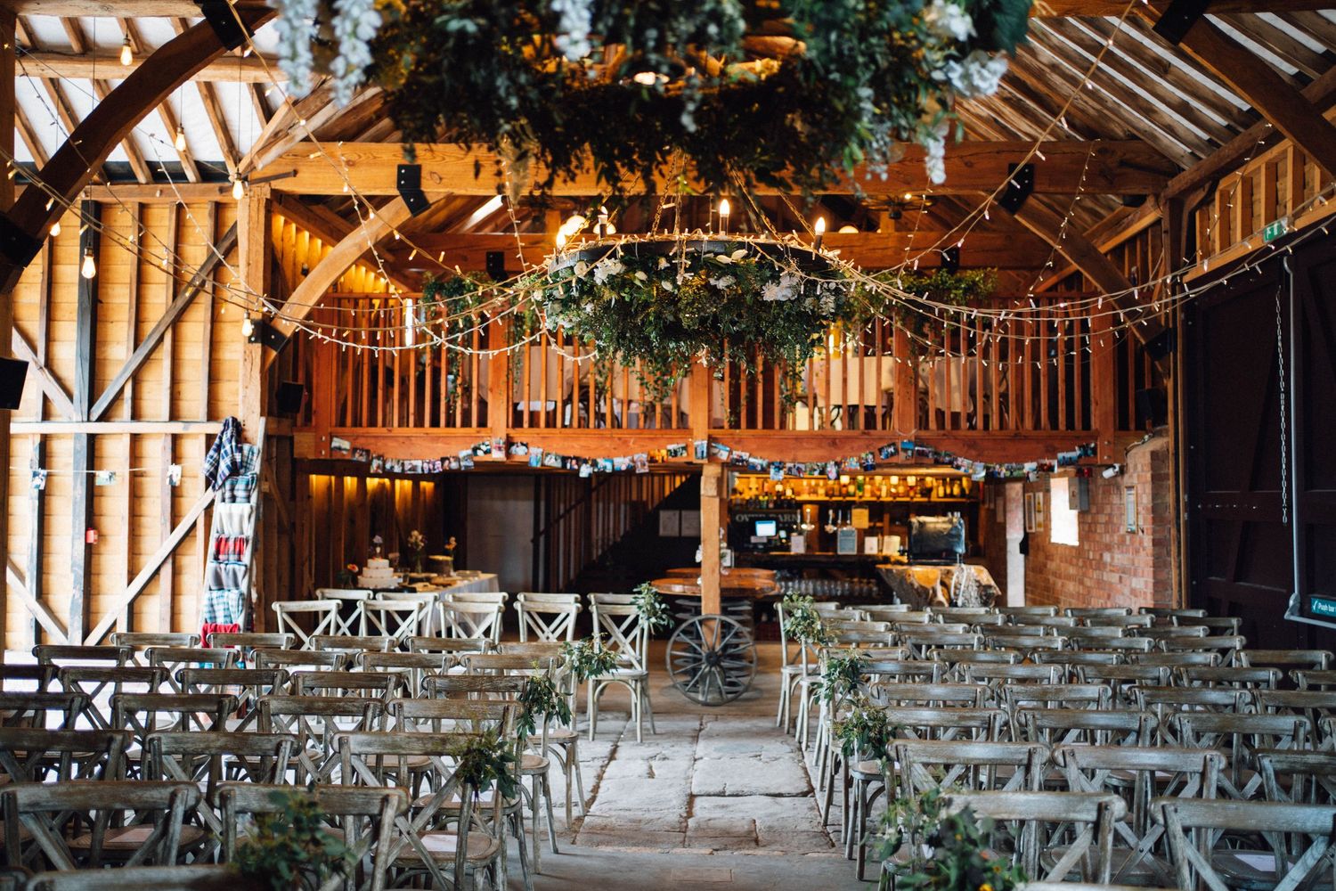 Rustic barn wedding venue with wooden beams and rows of chairs set up for ceremony.