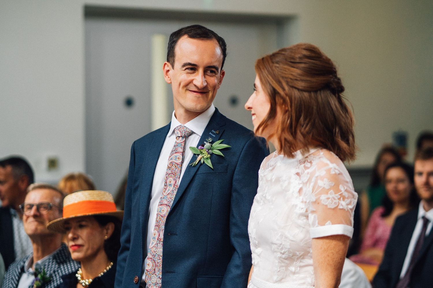 A happy couple shares a joyful moment during their wedding ceremony in an elegant indoor setting.
