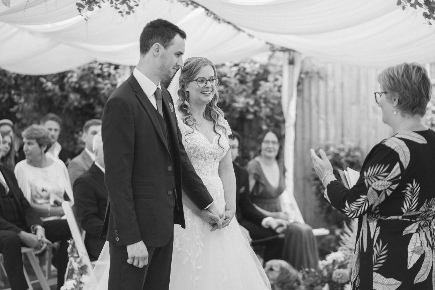 Black and white photo collage showing joyful moments from a wedding celebration with guests and confetti.