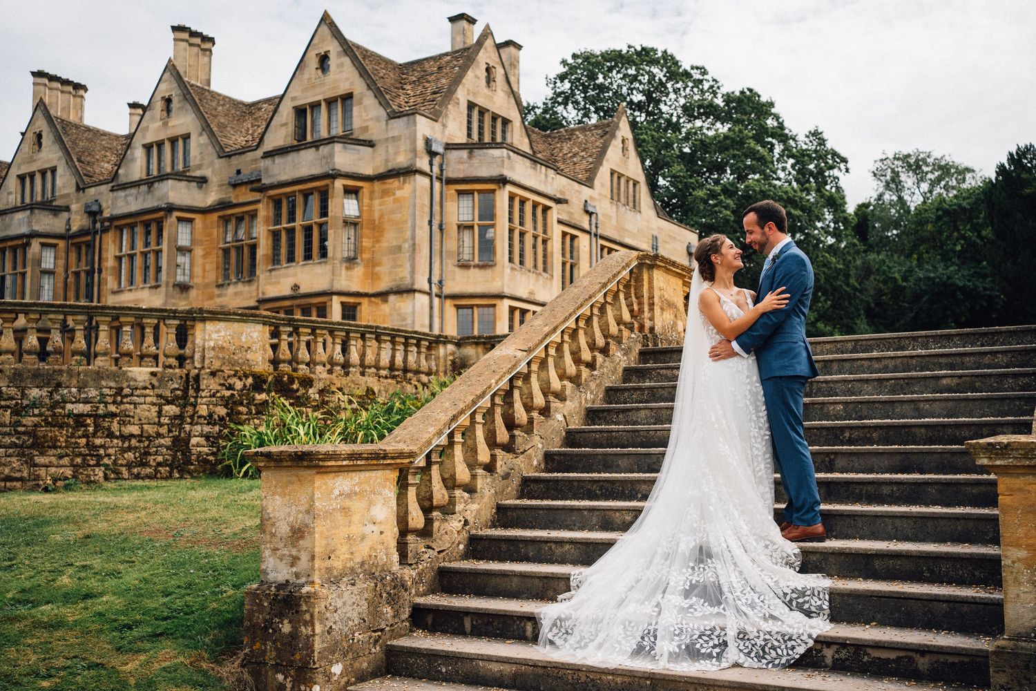 Romantic wedding photos captured on grand stone steps of a historic manor house.