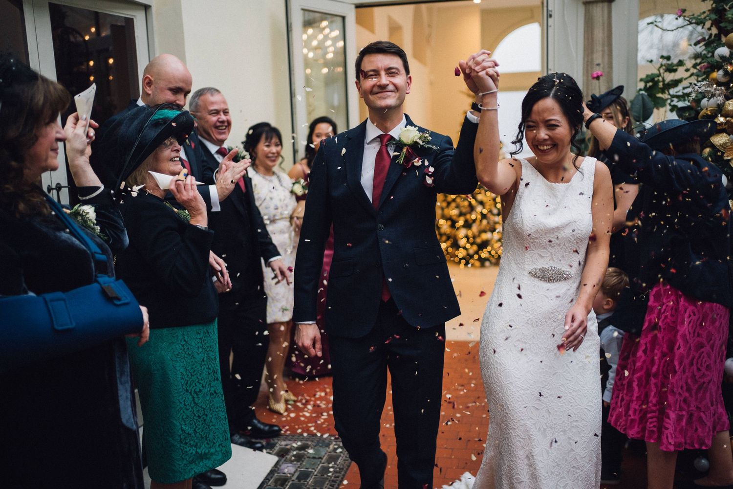 Wedding guests celebrate by throwing confetti at the newlyweds during their joyous exit.