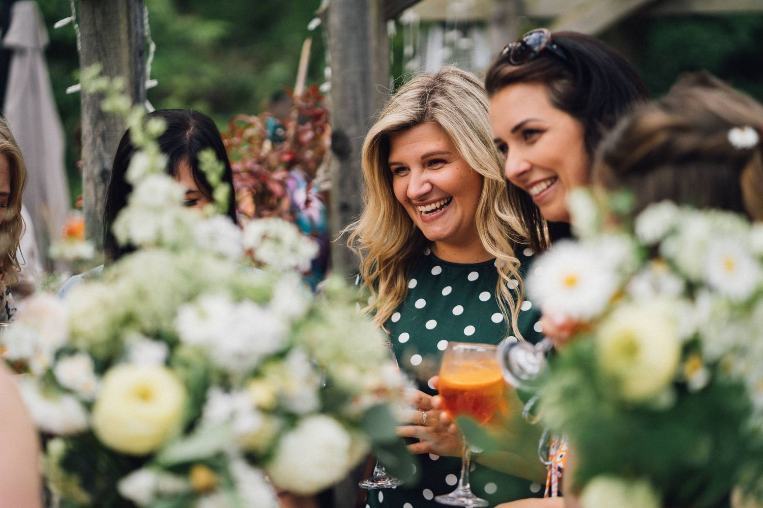 Wedding guests enjoying outdoor reception with floral decorations.