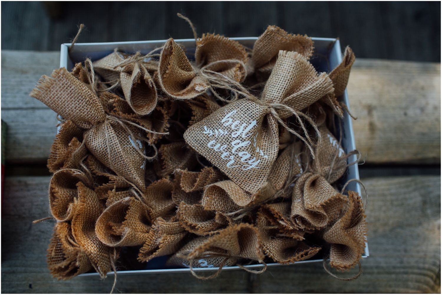 Rustic burlap wedding decorations arranged in vintage metal container.