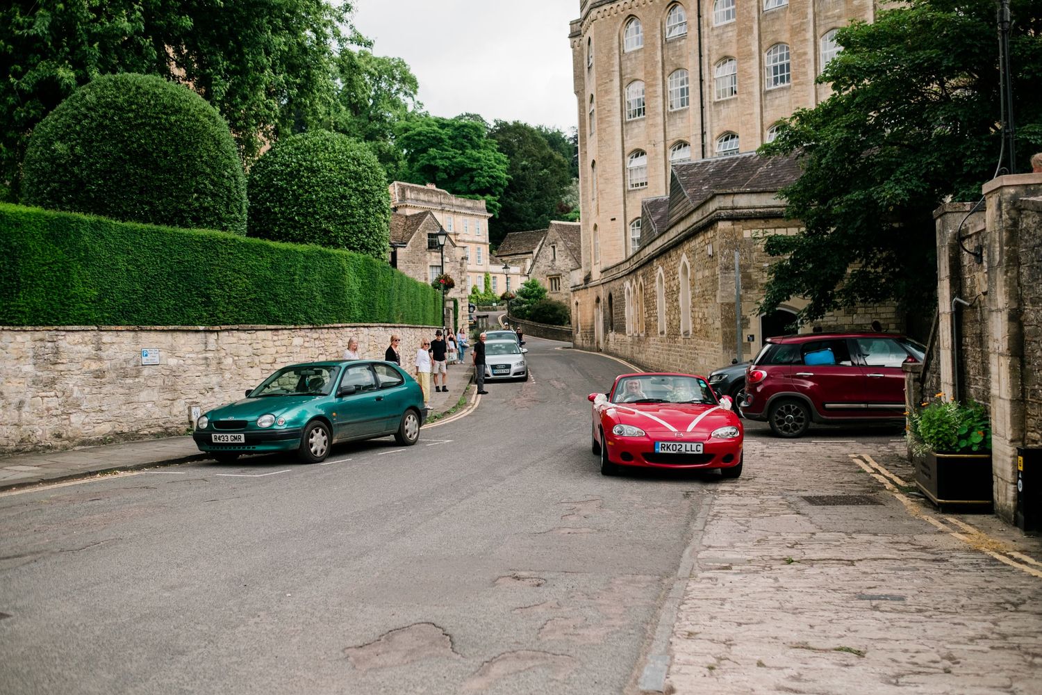 Stone building exterior with parked cars and traditional architecture.