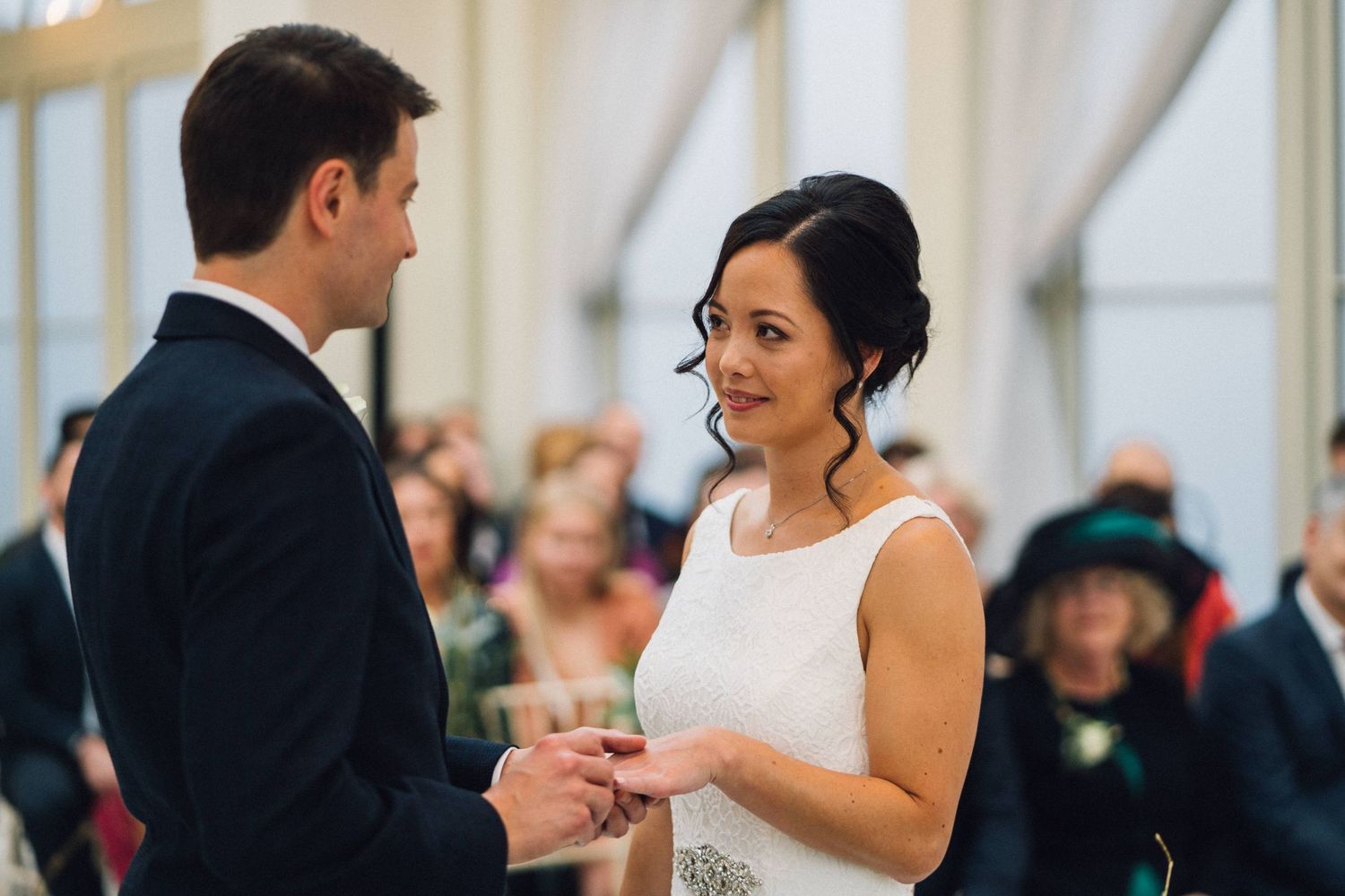Couple sharing a romantic moment during their wedding reception in an elegant white room.