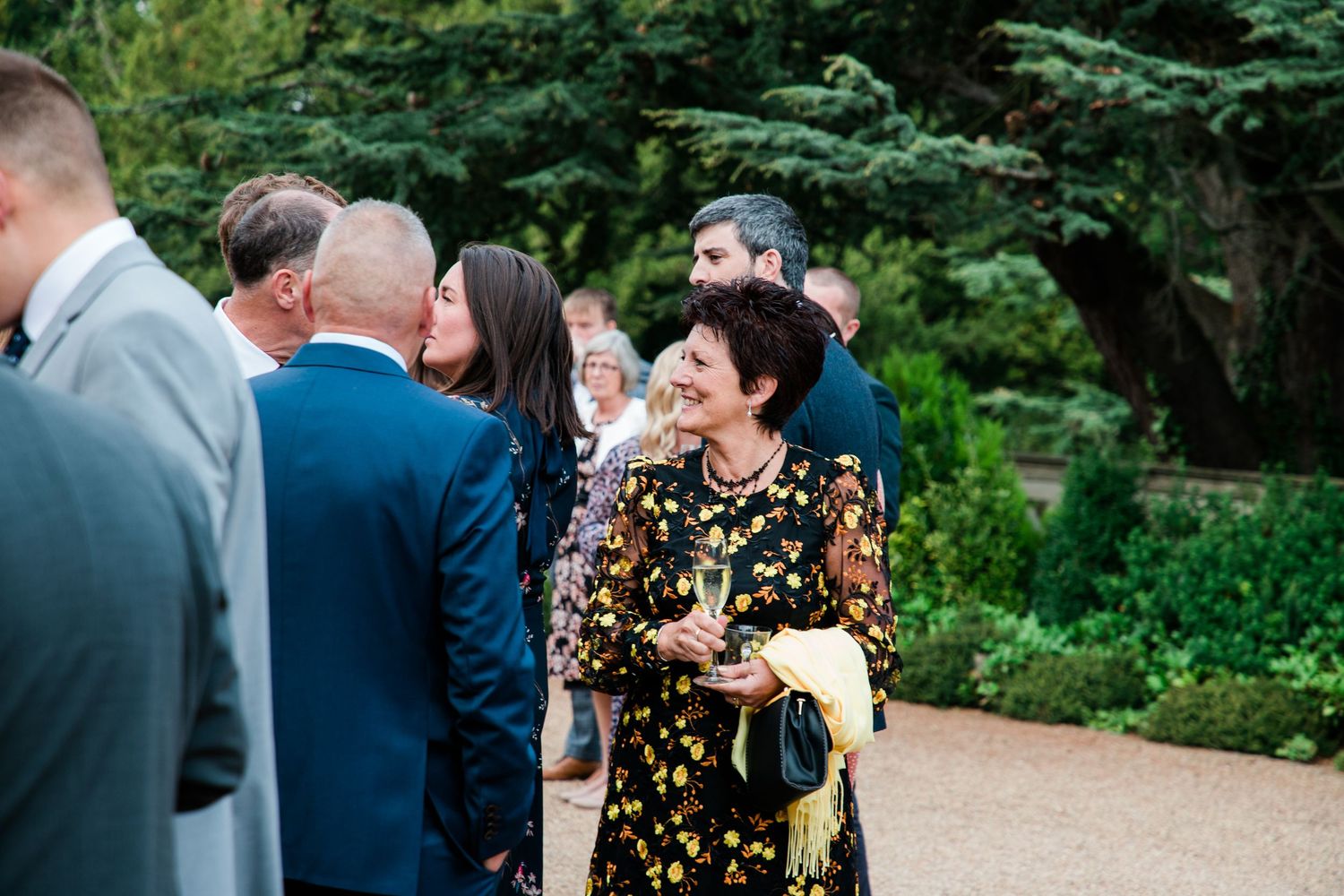 Wedding guests enjoying outdoor celebrations in a lush garden setting.