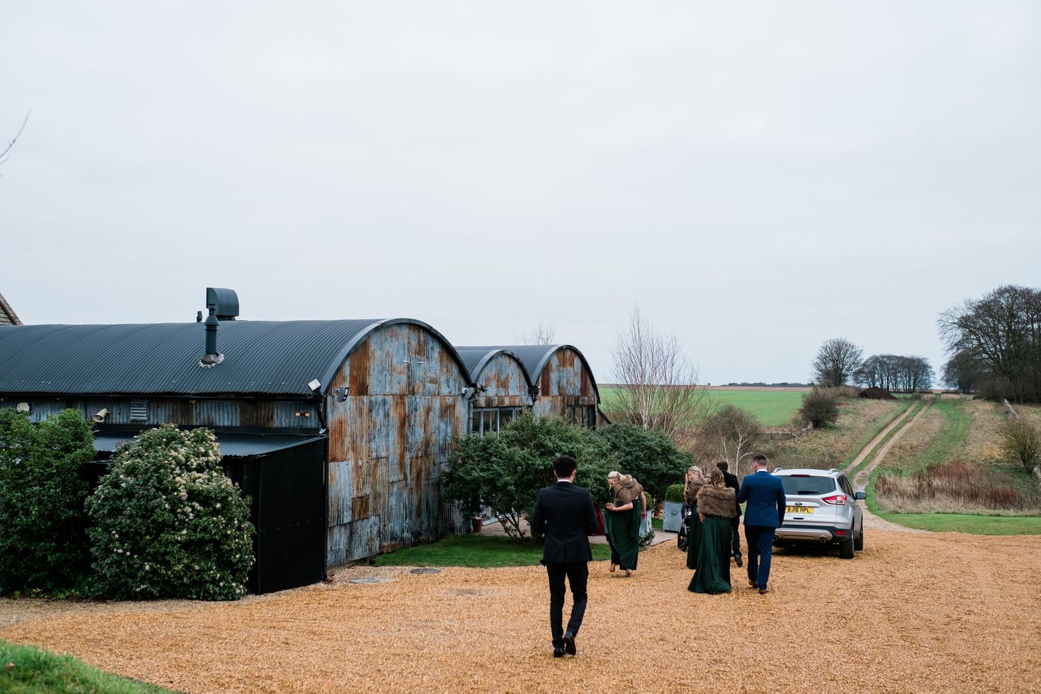 Rustic barn venue exterior with weathered metal roofing and countryside views.