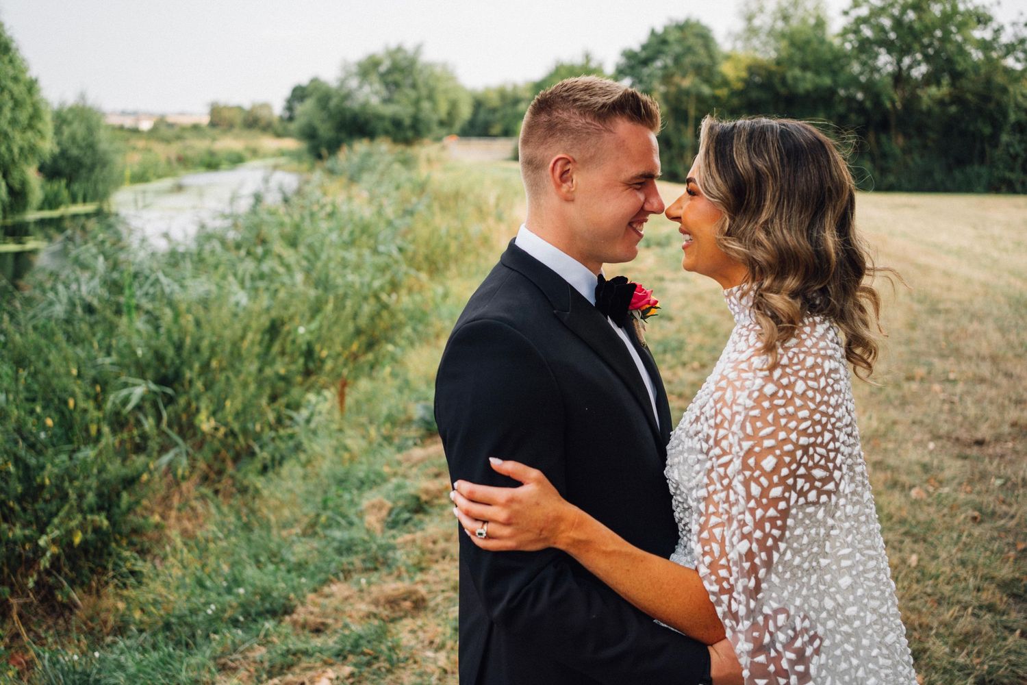 Elegant wedding couple sharing intimate moments in a natural outdoor setting.