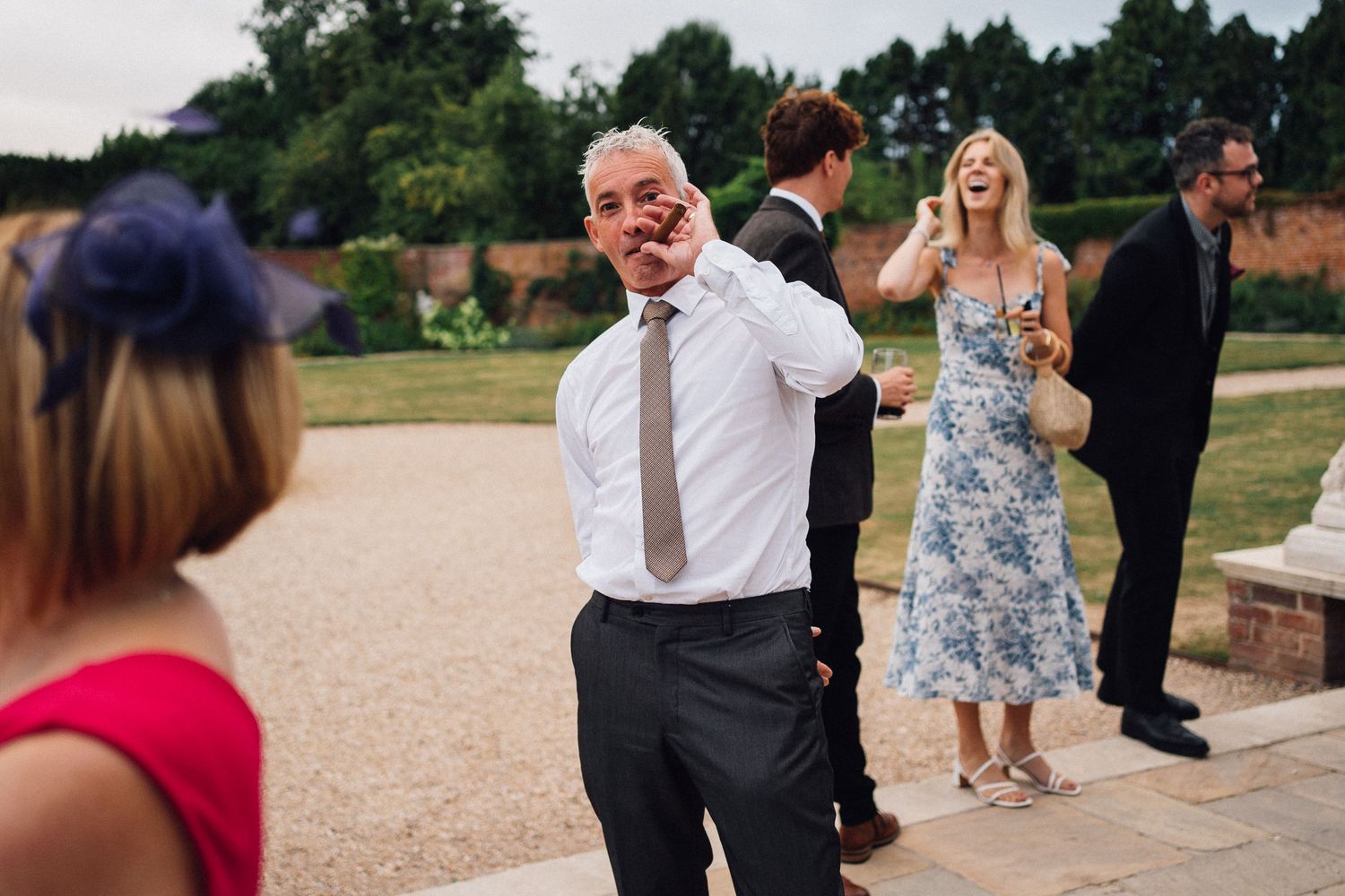 Wedding guests dance and celebrate on outdoor patio during reception party.